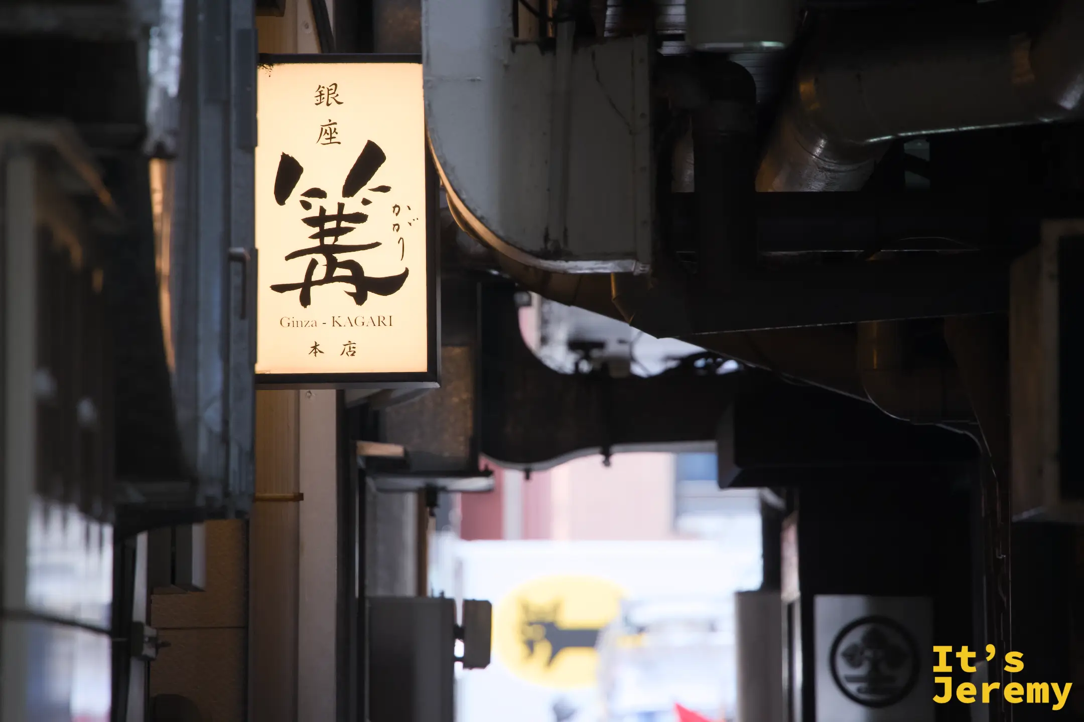 夜晚巷弄裡的篝招牌燈箱，「銀座 篝 Ginza-KAGARI 本店」字樣清晰，背景是銀座小巷的街景