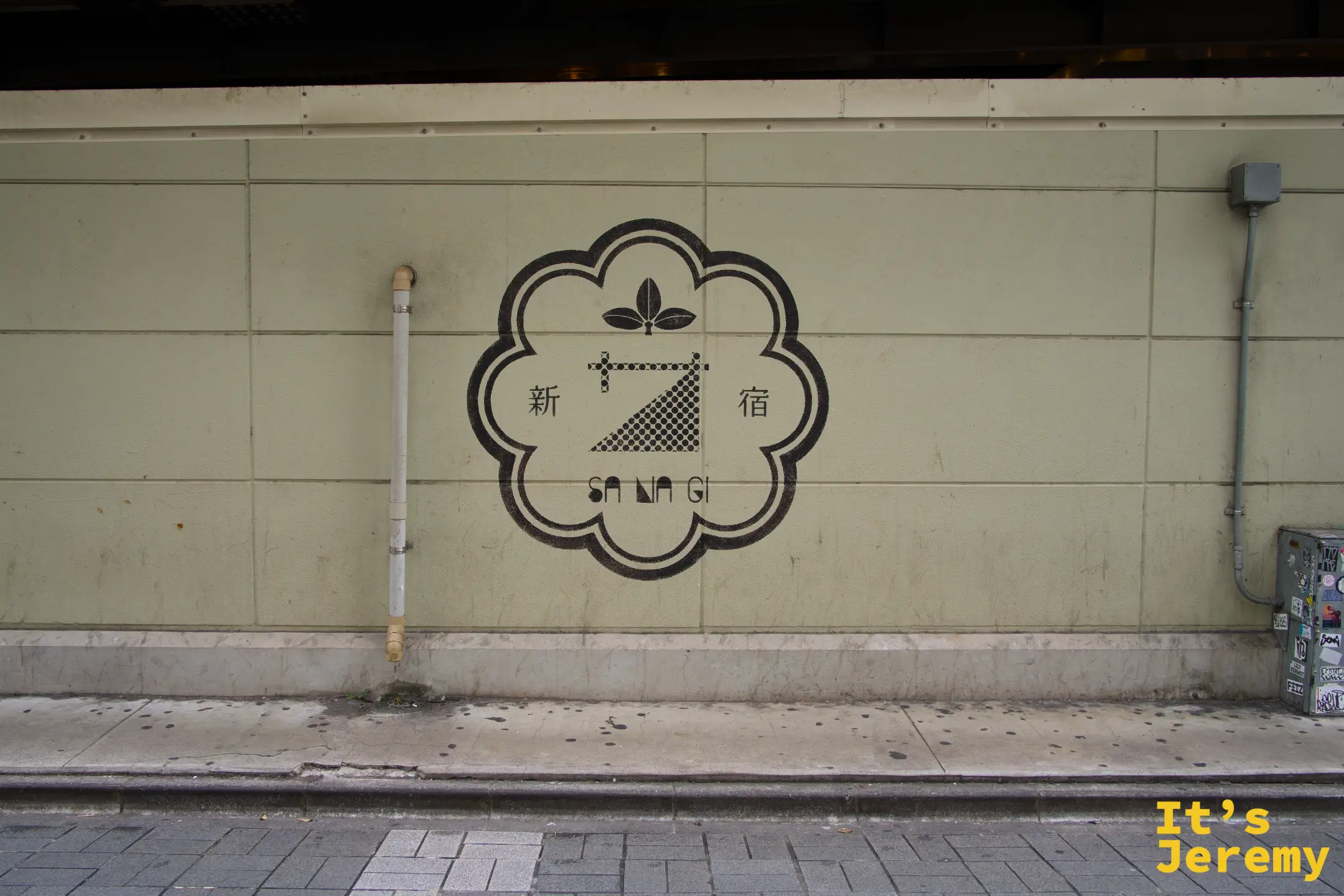 新宿 SANAGI 品牌 Logo 印在建築外牆的灰白瓷磚上,圓框紋樣帶有和式設計感
