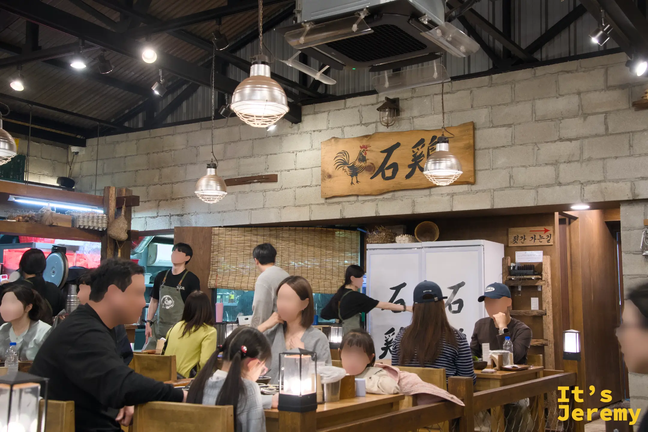 「石雞」大木牌高掛廚房入口上方，整間店氣場都在這塊牌子裡