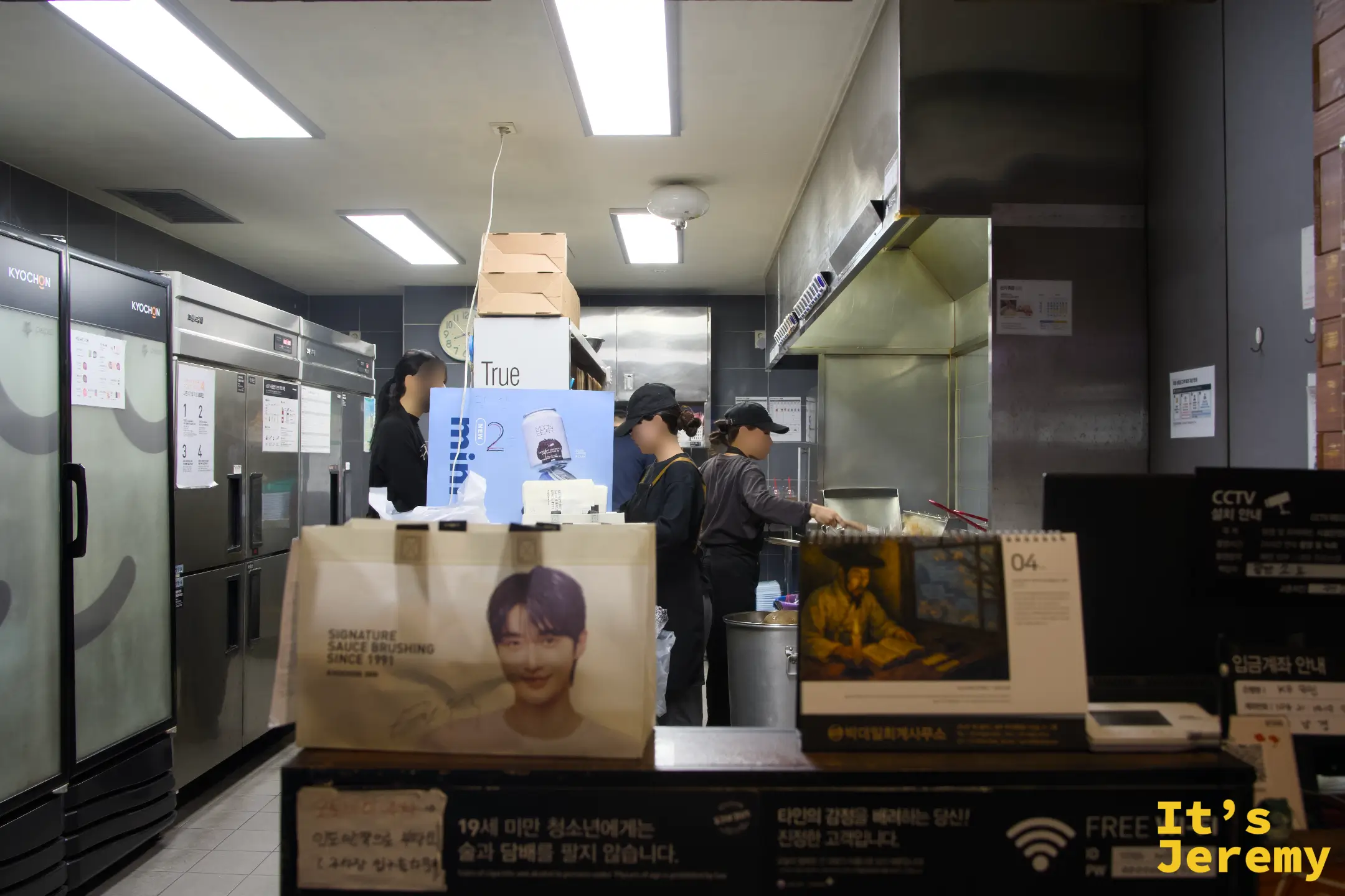 교촌廚房備餐中,桌上的白色外帶袋印著代言人的大頭照——提著這個袋子走出去,回頭率有點高
