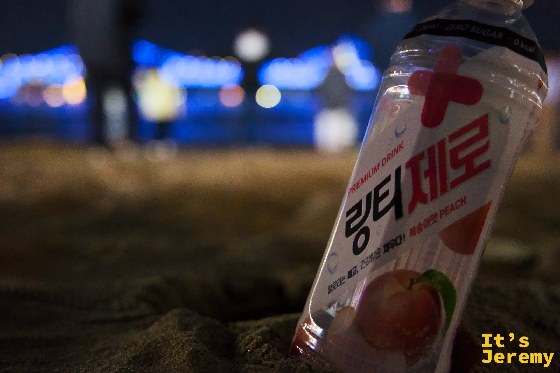 링티 제로插在廣安里沙灘上，背後是廣安大橋藍色燈光
