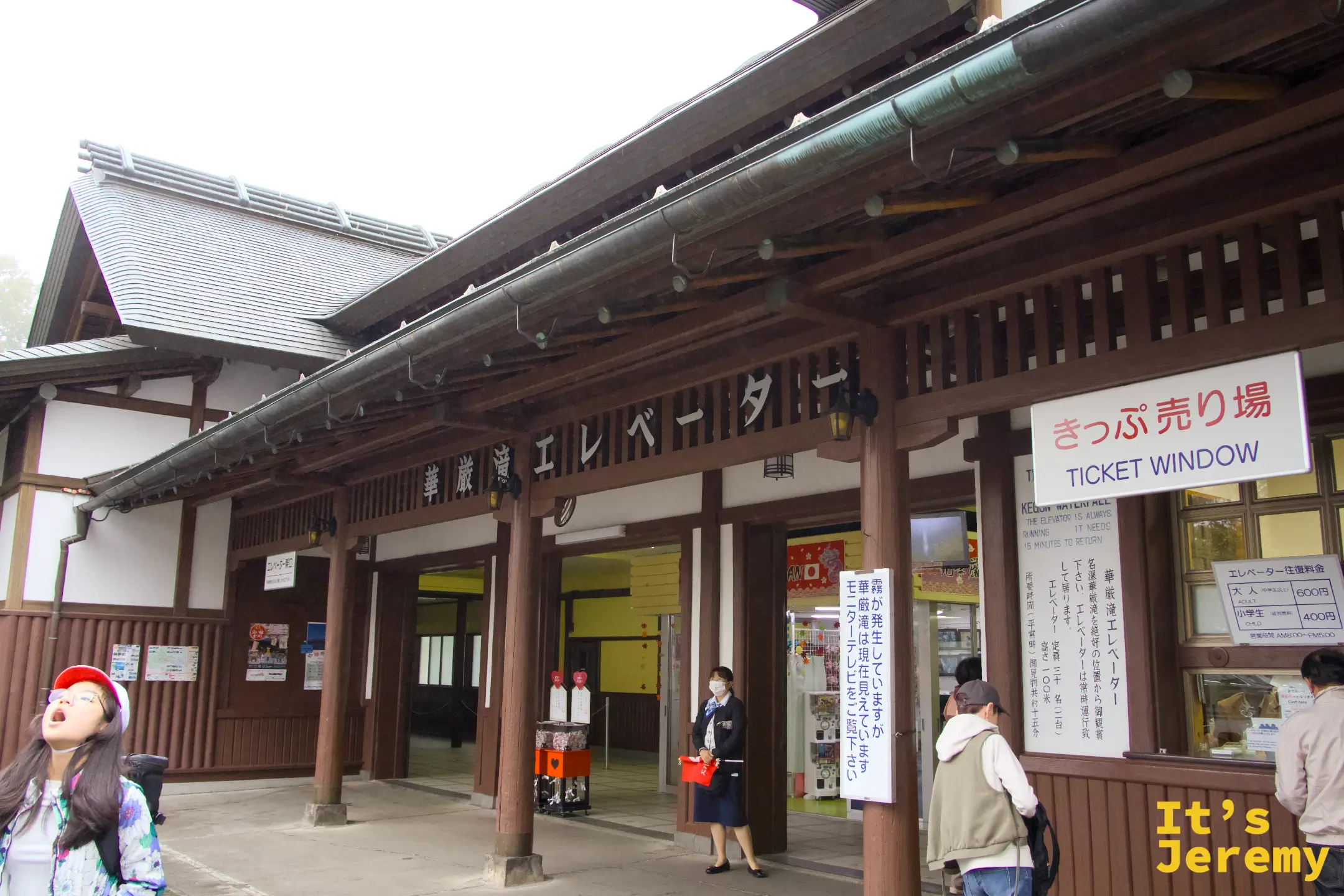 華嚴瀑布電梯售票口外觀，傳統日式木造建築，招牌寫著「きっぷ売り場」，門口有工作人員引導