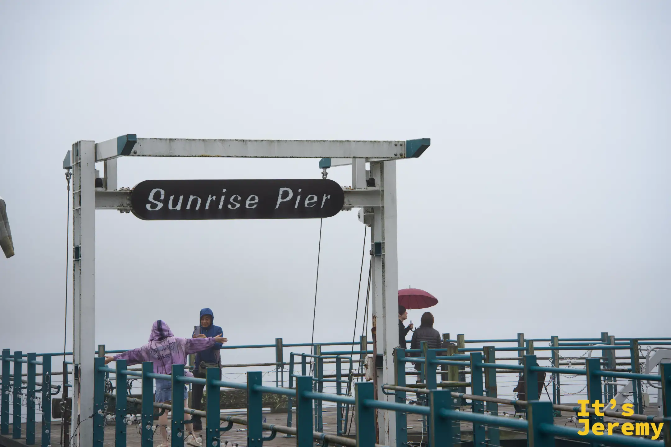 中禪寺湖「Sunrise Pier」牌子，霧中有遊客撐傘