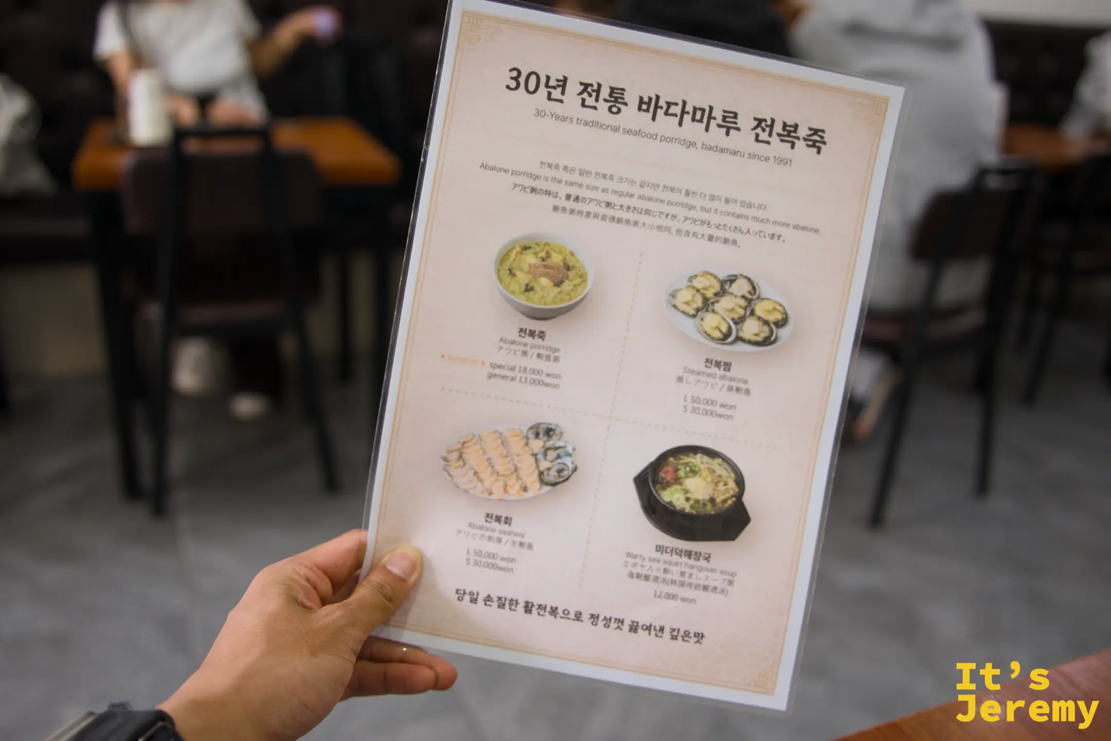 手持菜單一覽，四項主要品項一目了然：전복죽、전복찜、전복회、미더덕해장국