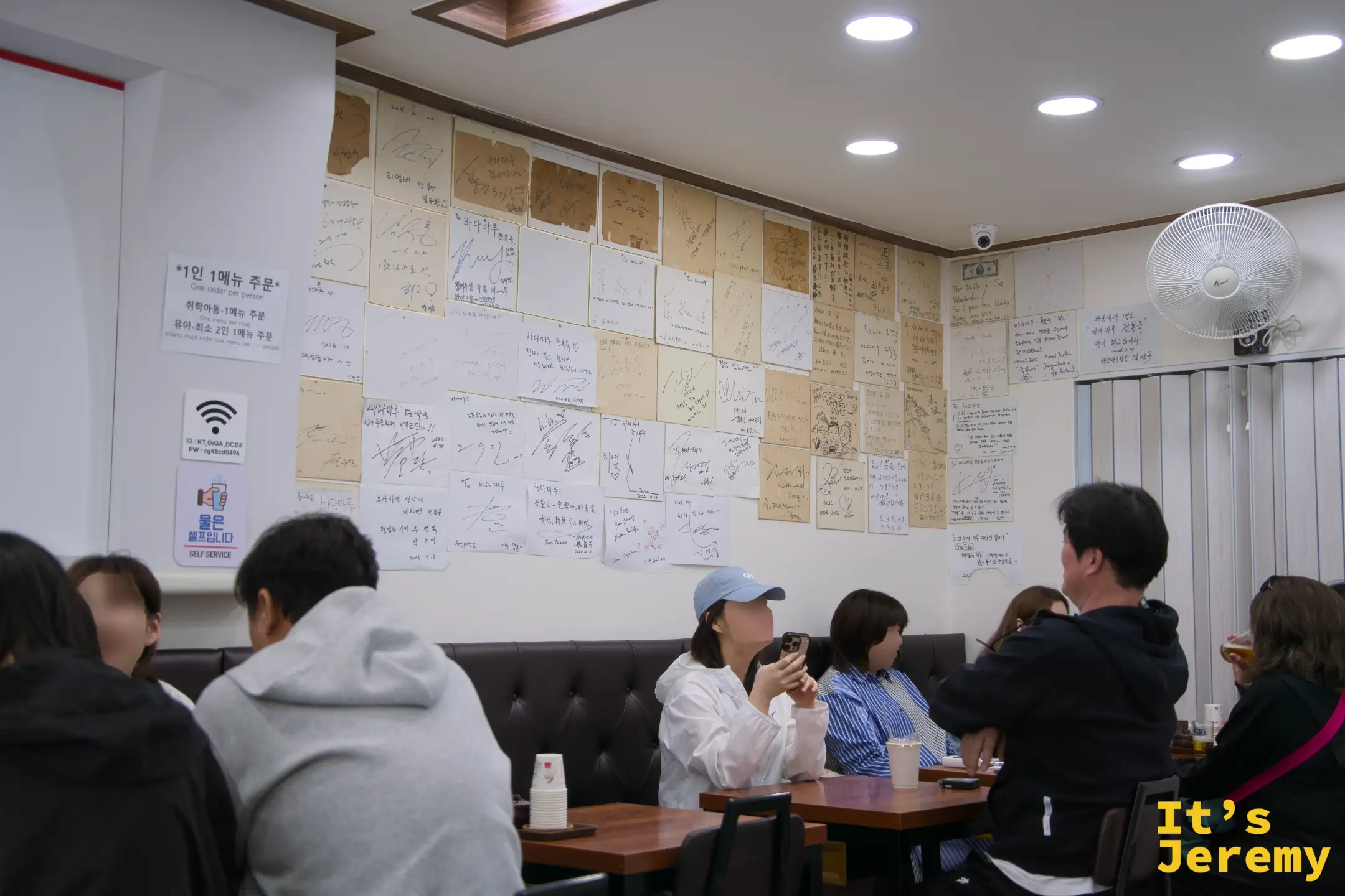 店內一整面牆貼滿各地旅人的手寫留言，從釜山在地客到台灣、新加坡來的遠道旅人都留下了字跡