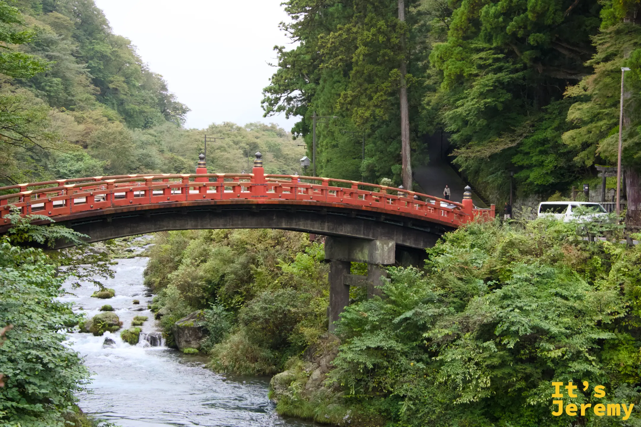 神橋全景，朱紅拱橋橫跨大谷川，背景樹林