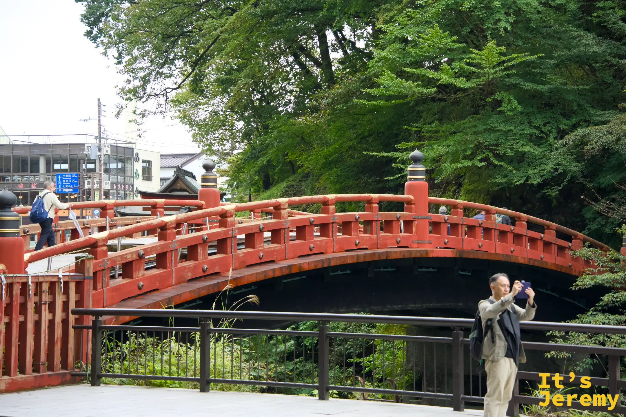 神橋另一角度全景，前景有遊客在拍照