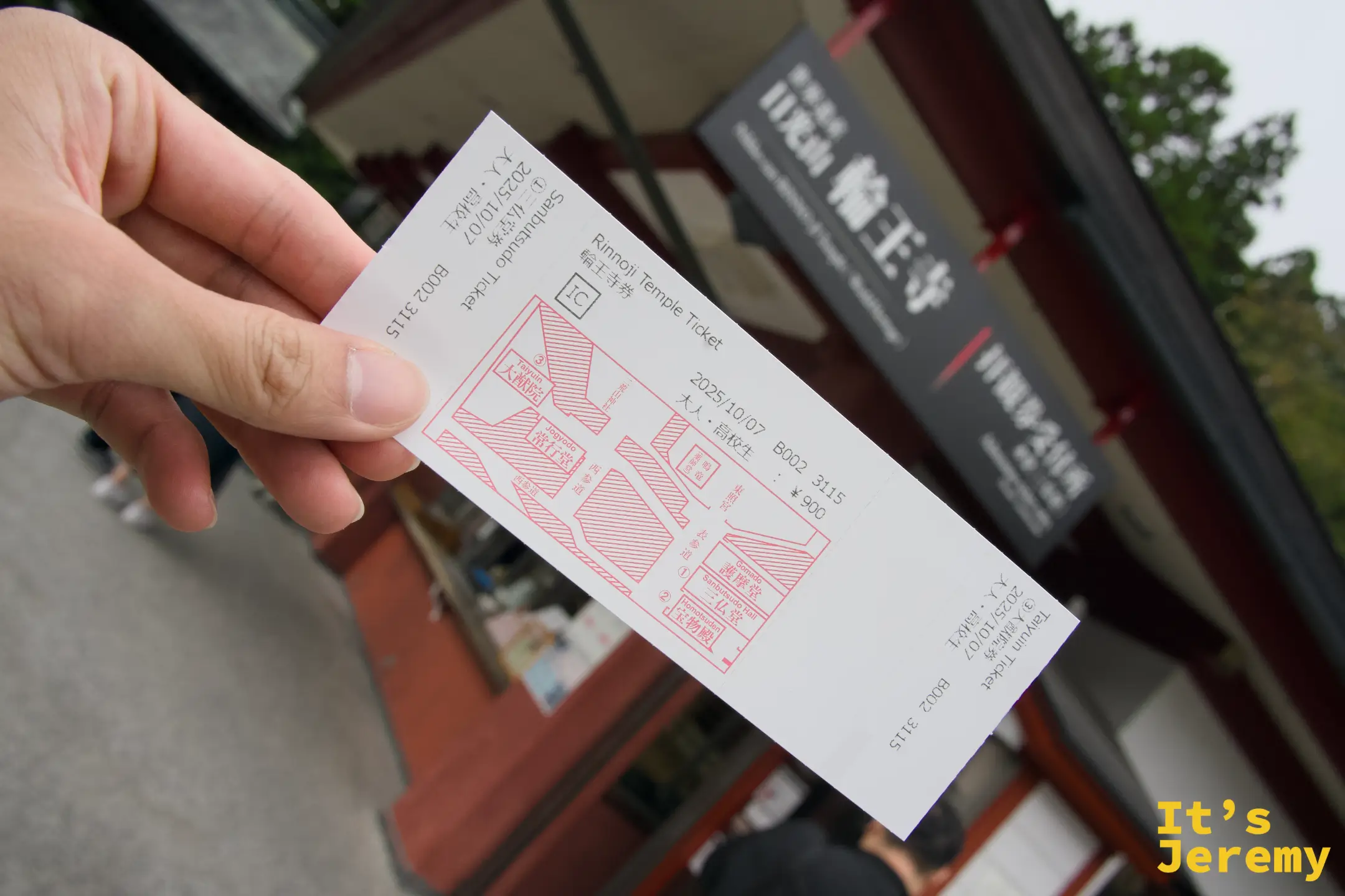 手持輪王寺聯票，背景是寺院招牌，票面印有三仏堂與大猷院兩處的配置圖，¥900