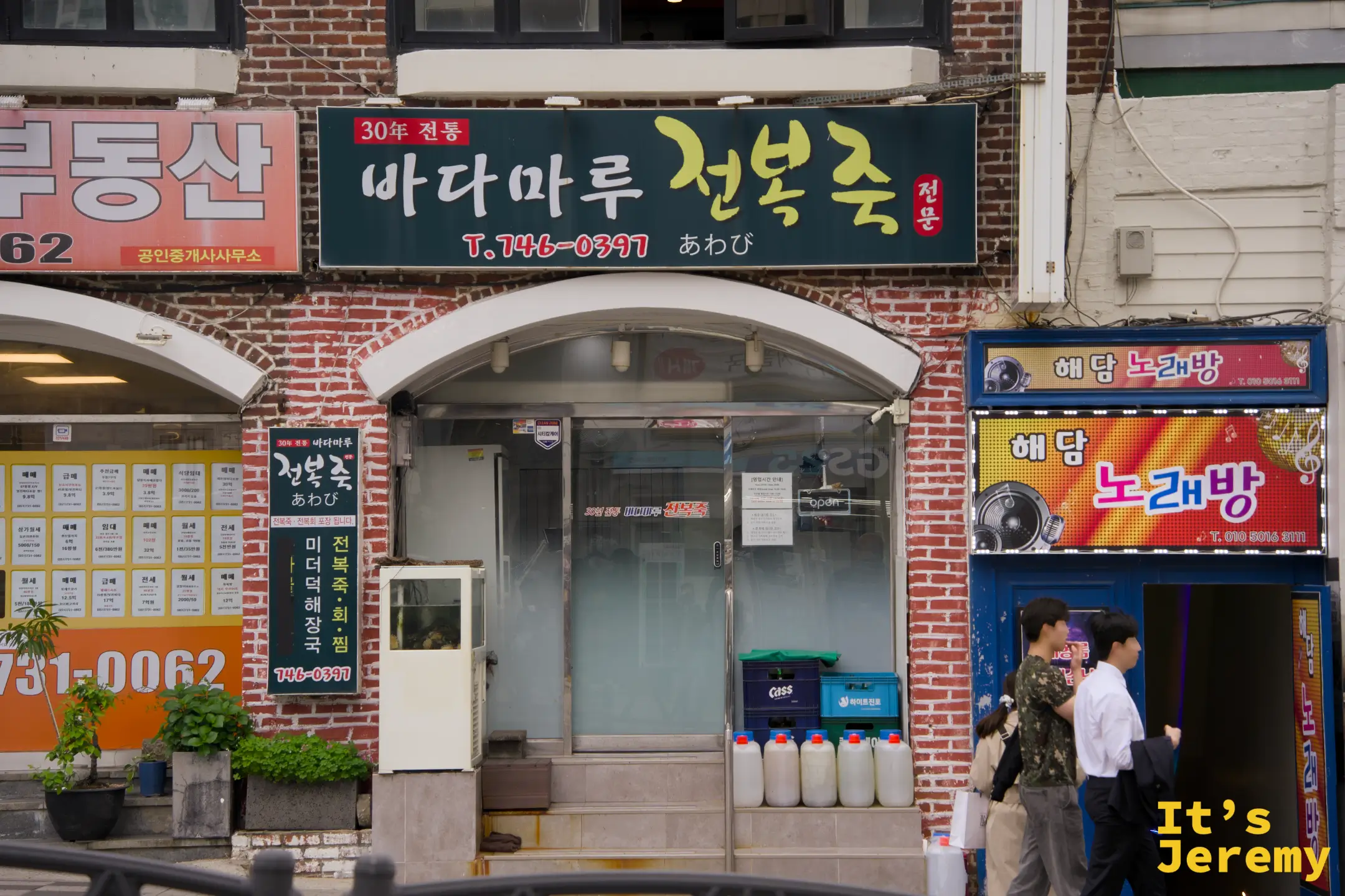 30년 전통 바다마루 전복죽，紅磚外牆配上深綠色招牌，是這條街最有底氣的一塊牌子