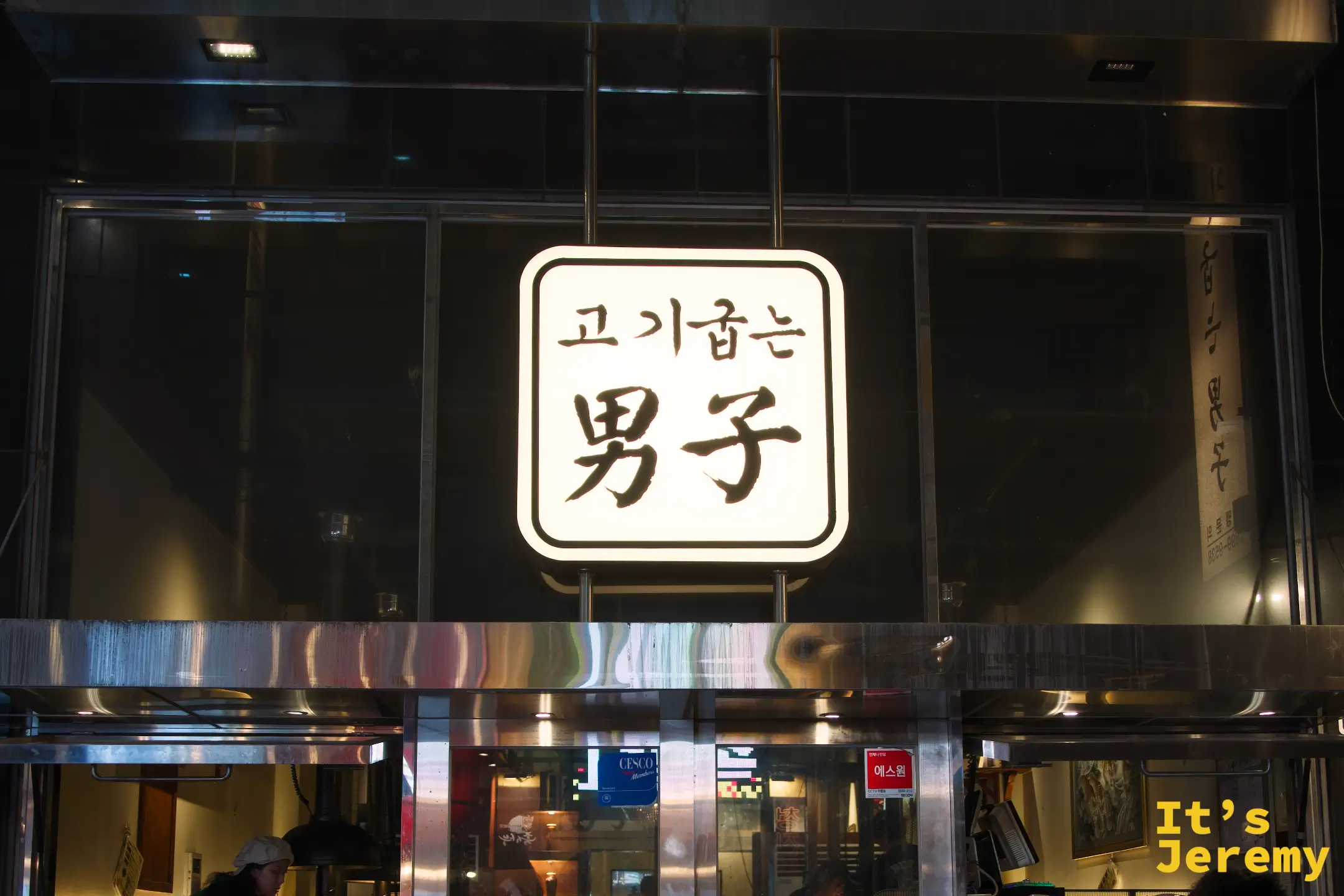 고기굽는男子 男子烤肉招牌，黑底白字在夜色中靜靜發光