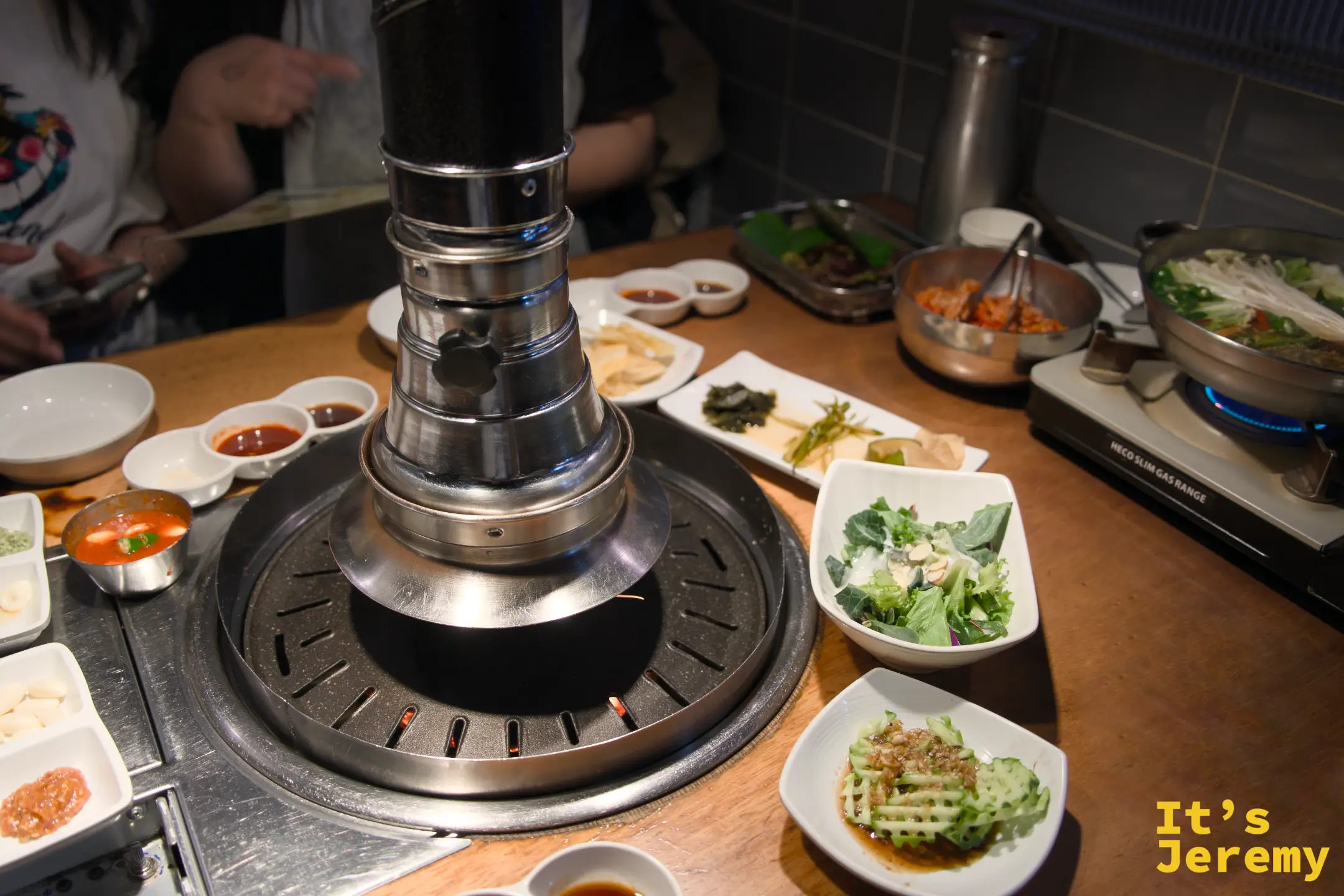 滿桌的前菜小碟：生菜沙拉、醃漬海帶、涼拌青蔥、醋味黃瓜，配色清新，整桌從一開始就有儀式感