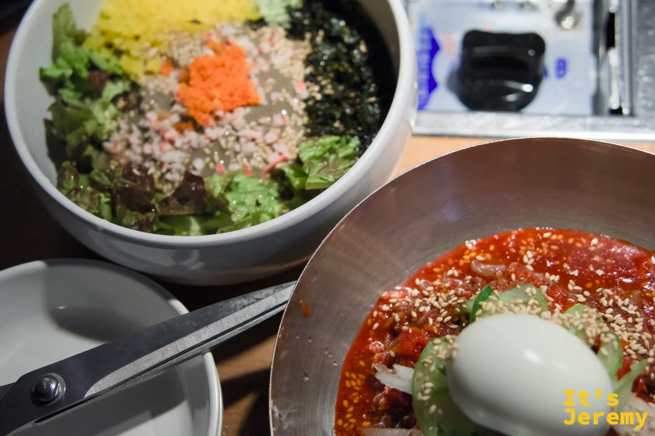 兩碗各有個性的主食同框：左邊蟹膏拌飯豐腴，右邊冷麵勁辣，截然不同卻相互互補