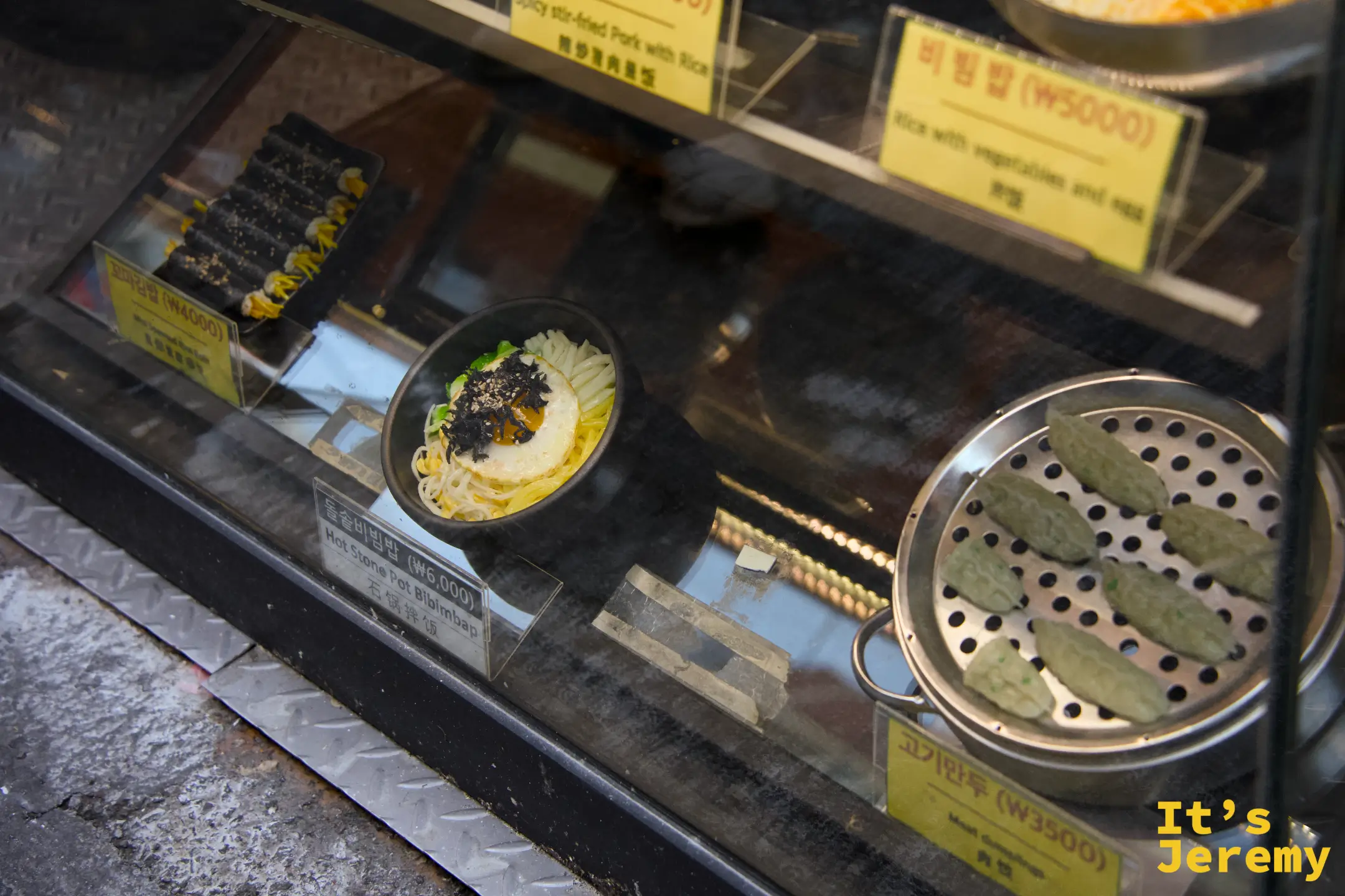 展示櫃下層可見꼬마김밥、돌솥비빔밥和고기만두的模型，一目了然