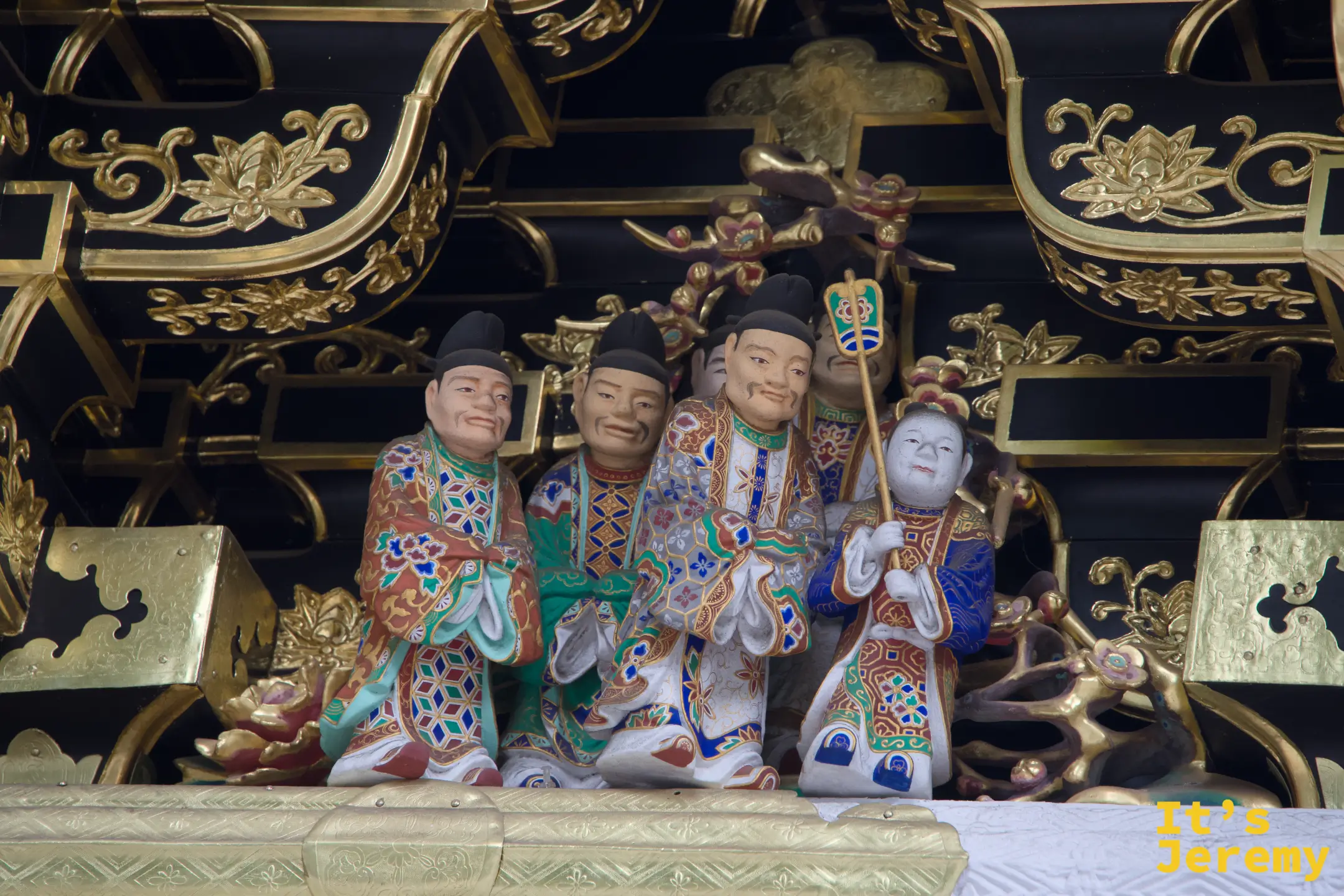 陽明門橫樑上的彩色人物雕刻，三位人物持笏站立，衣褶分明，色彩鮮豔