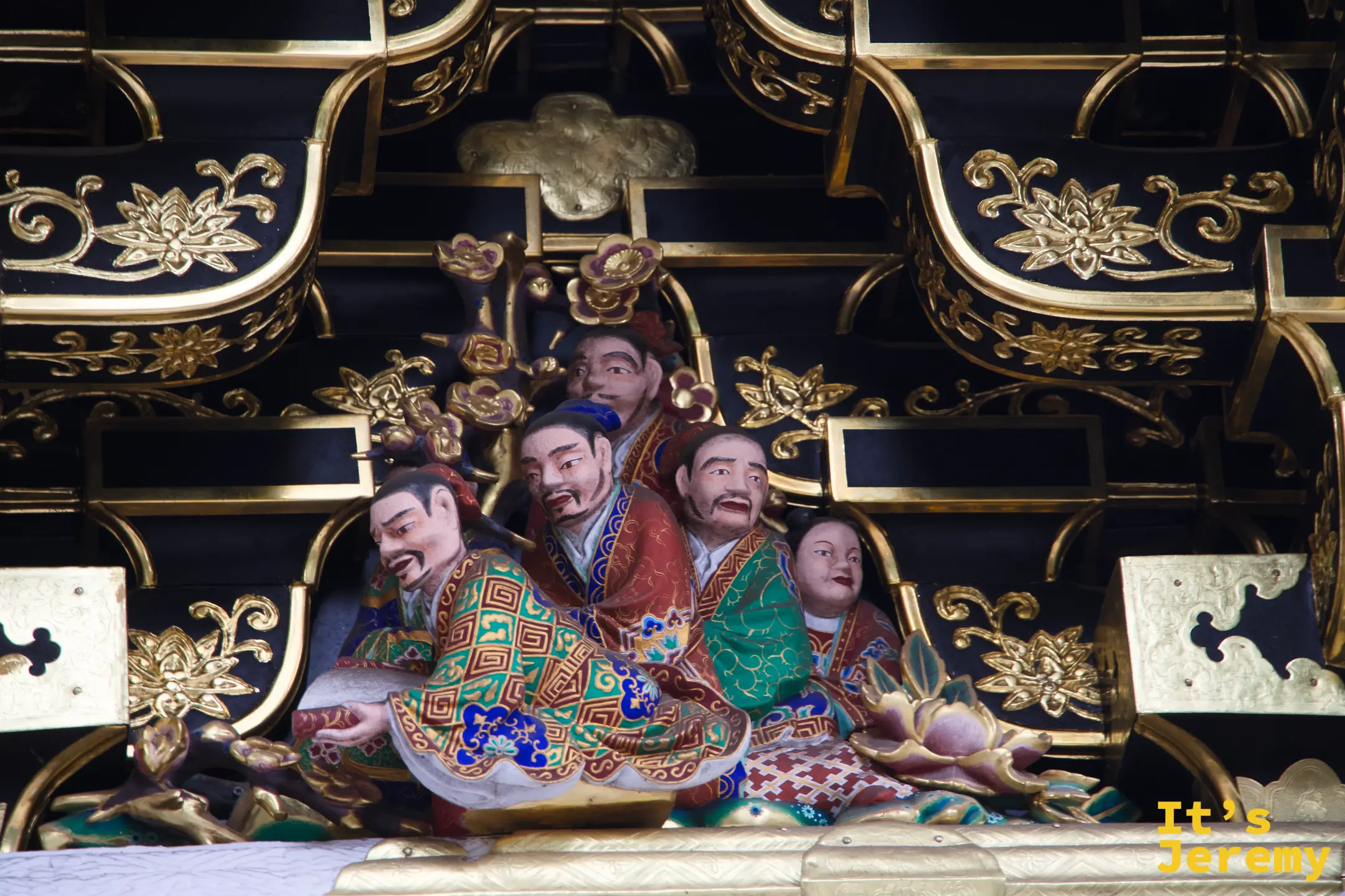 陽明門高處壁面雕刻，五位人物群像緊湊排列，表情與姿態細膩