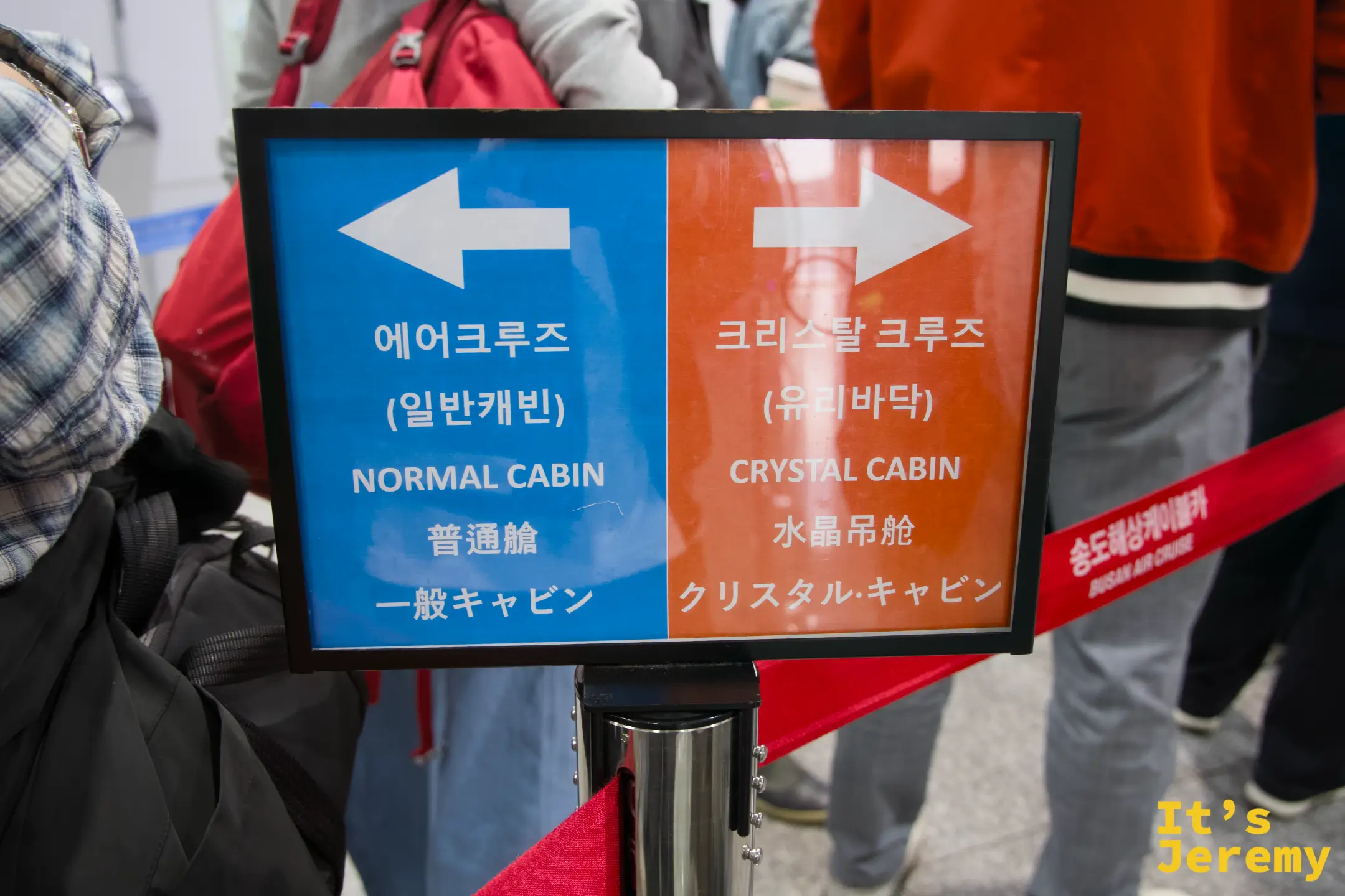 藍橘雙色搭乘指引牌，左邊藍色往一般車廂、右邊橘色往水晶車廂