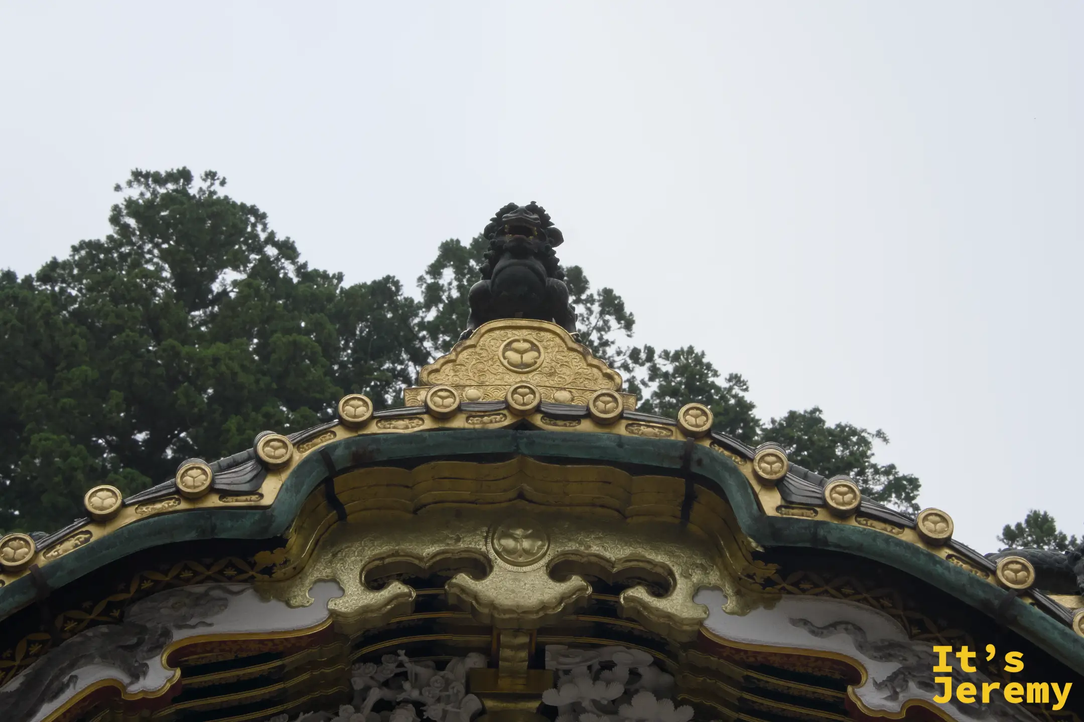 東照宮境內某棟建築的屋頂頂端，黑色獸形裝飾矗立在金色屋脊正中央，三葉葵家紋遍布屋脊邊緣