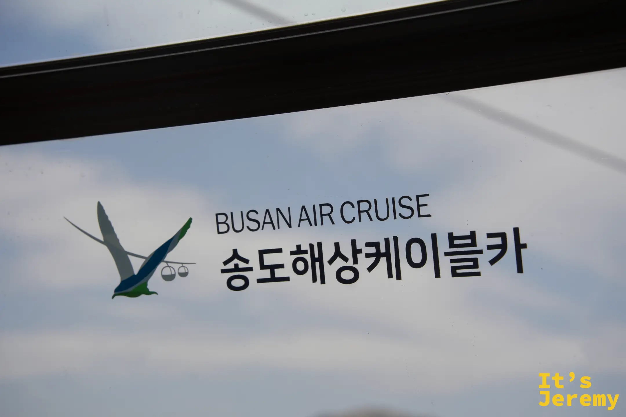 纜車廂玻璃上印著 BUSAN AIR CRUISE 松島海上纜車的海鷗 logo