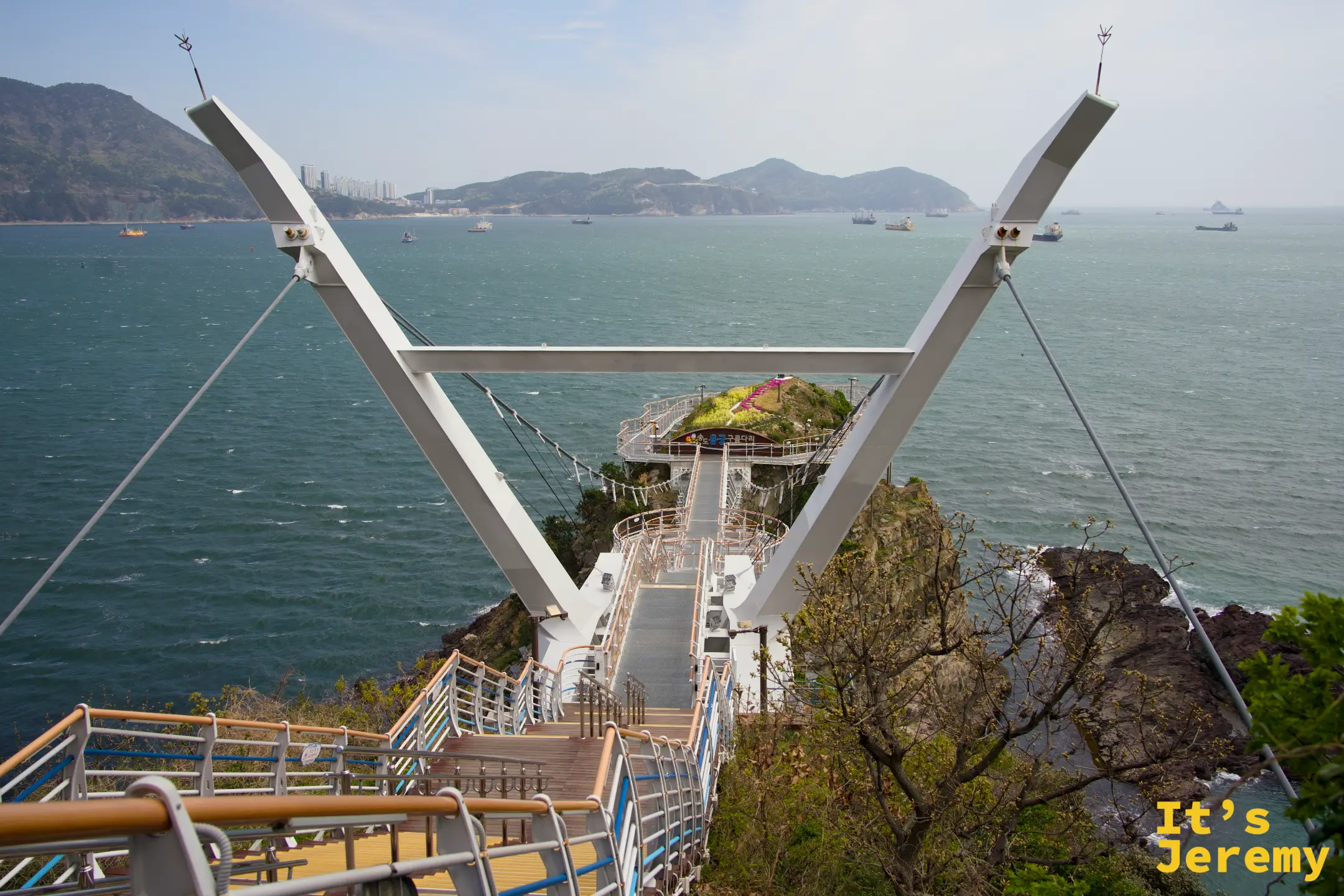 從高處俯瞰松島龍宮雲橋，V 字形白色門架與延伸至岬角的步道