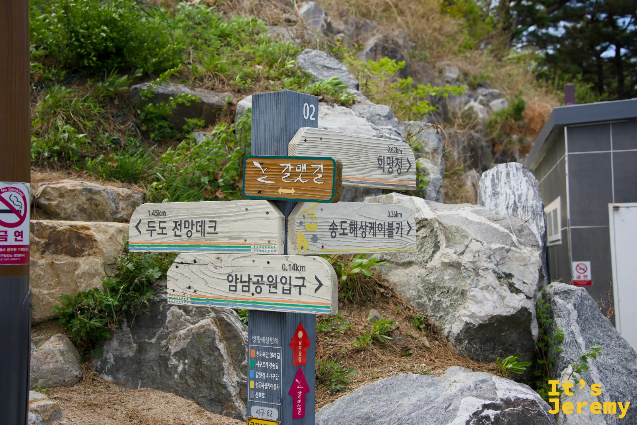 岩南公園的木製方向指標牌，以韓文標示往燈塔觀景台、松島海上纜車等方向