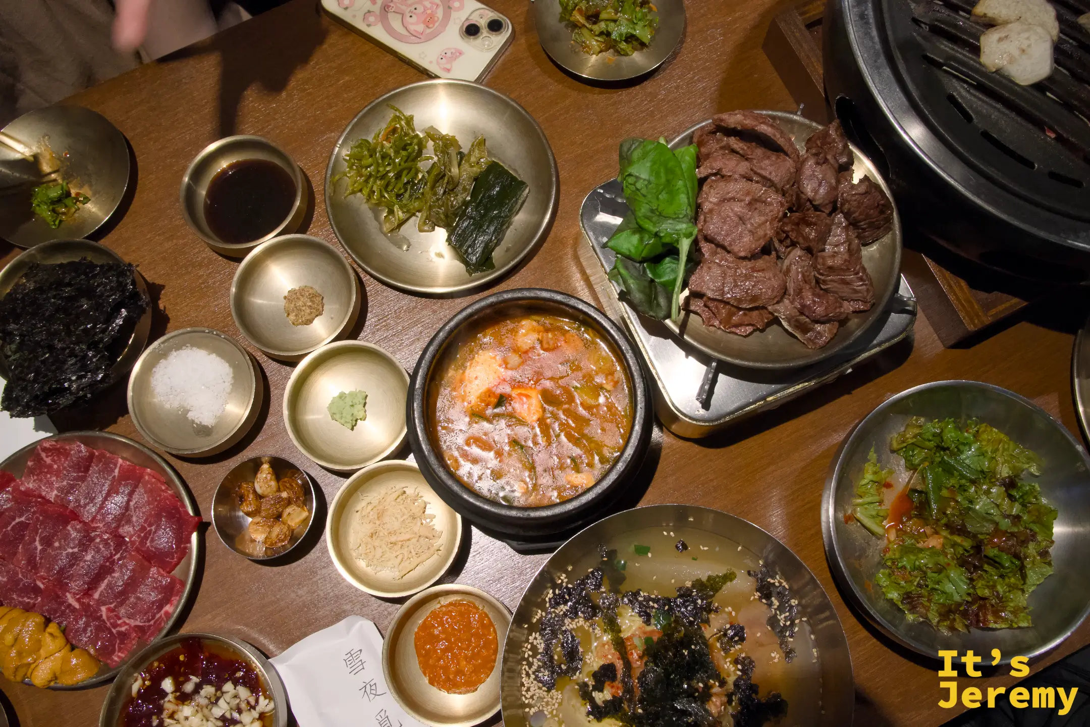 俯拍整桌：生肉盤、嫩豆腐鍋、烤好的肉、冰麵、各式小菜同時登場