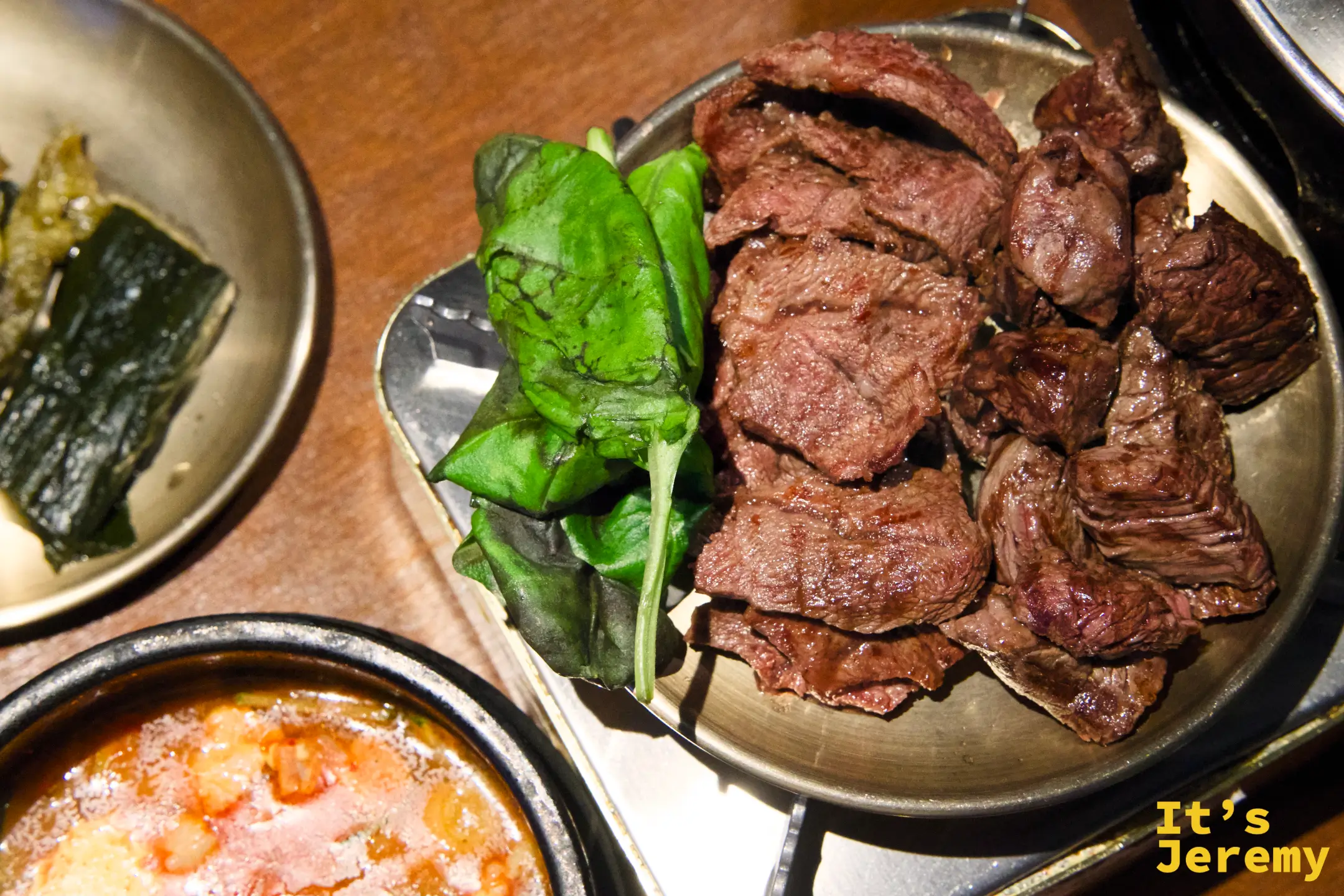 烤好的韓牛移至備料盤，搭配芝麻葉，旁邊是仍在滾的순두부