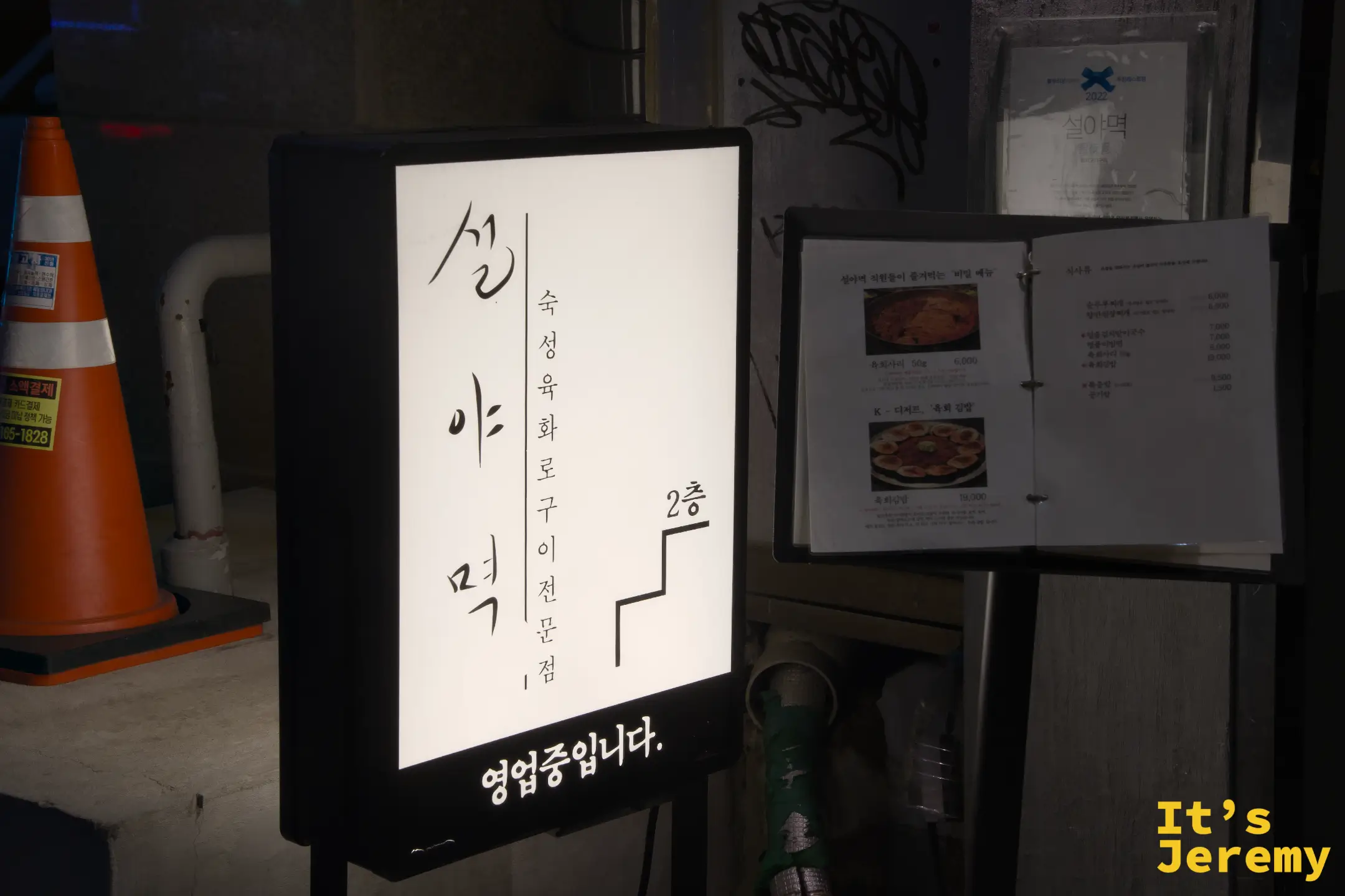 설아먹夜晚的招牌燈箱，毛筆字與「2층」指引清晰