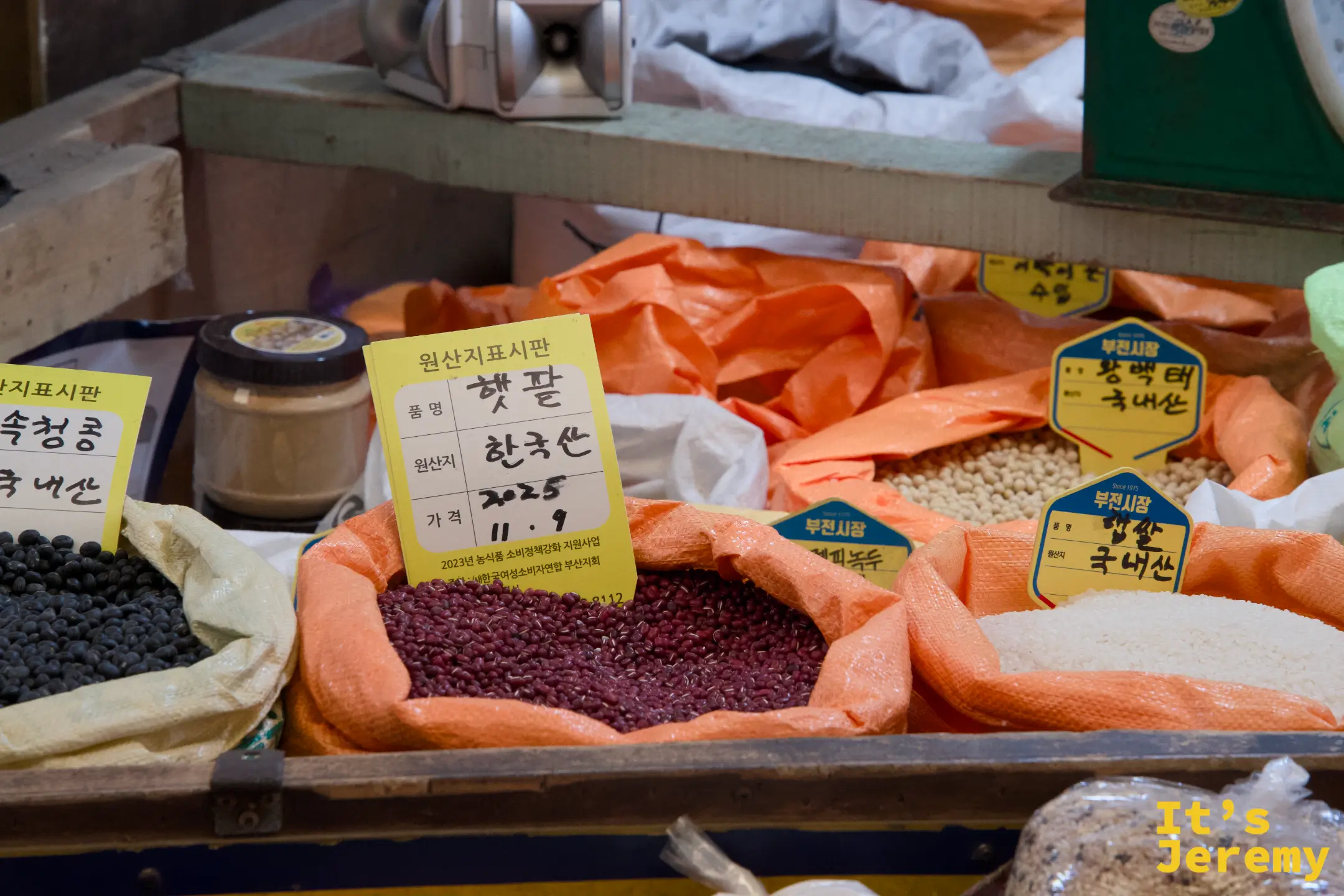 雜糧攤,紅豆、黑豆、白米各色穀物整齊陳列,標示原產地
