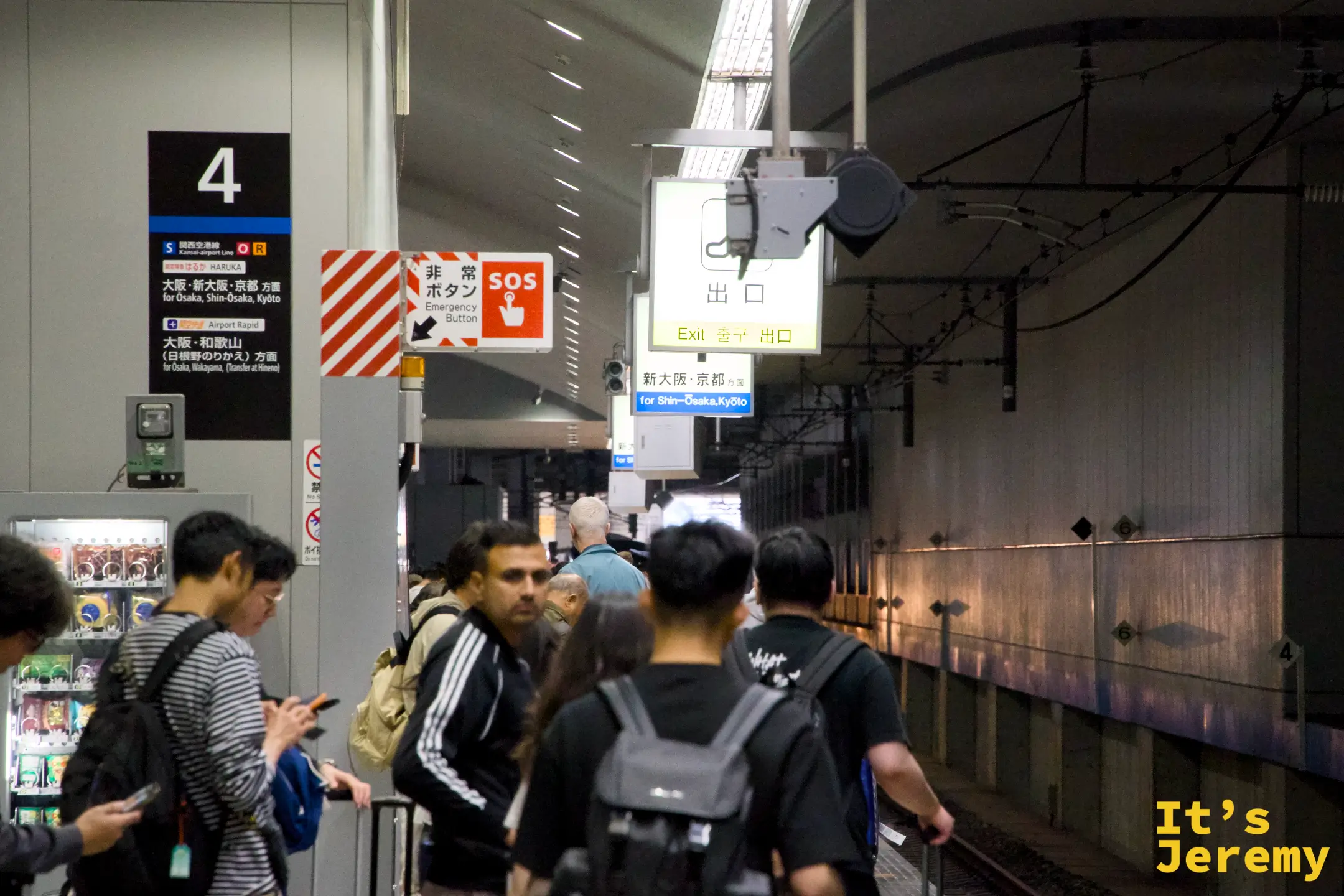 關西空港 4 番ホーム月台，旅客拎著行李等候，指示牌標示「新大阪・京都」方向