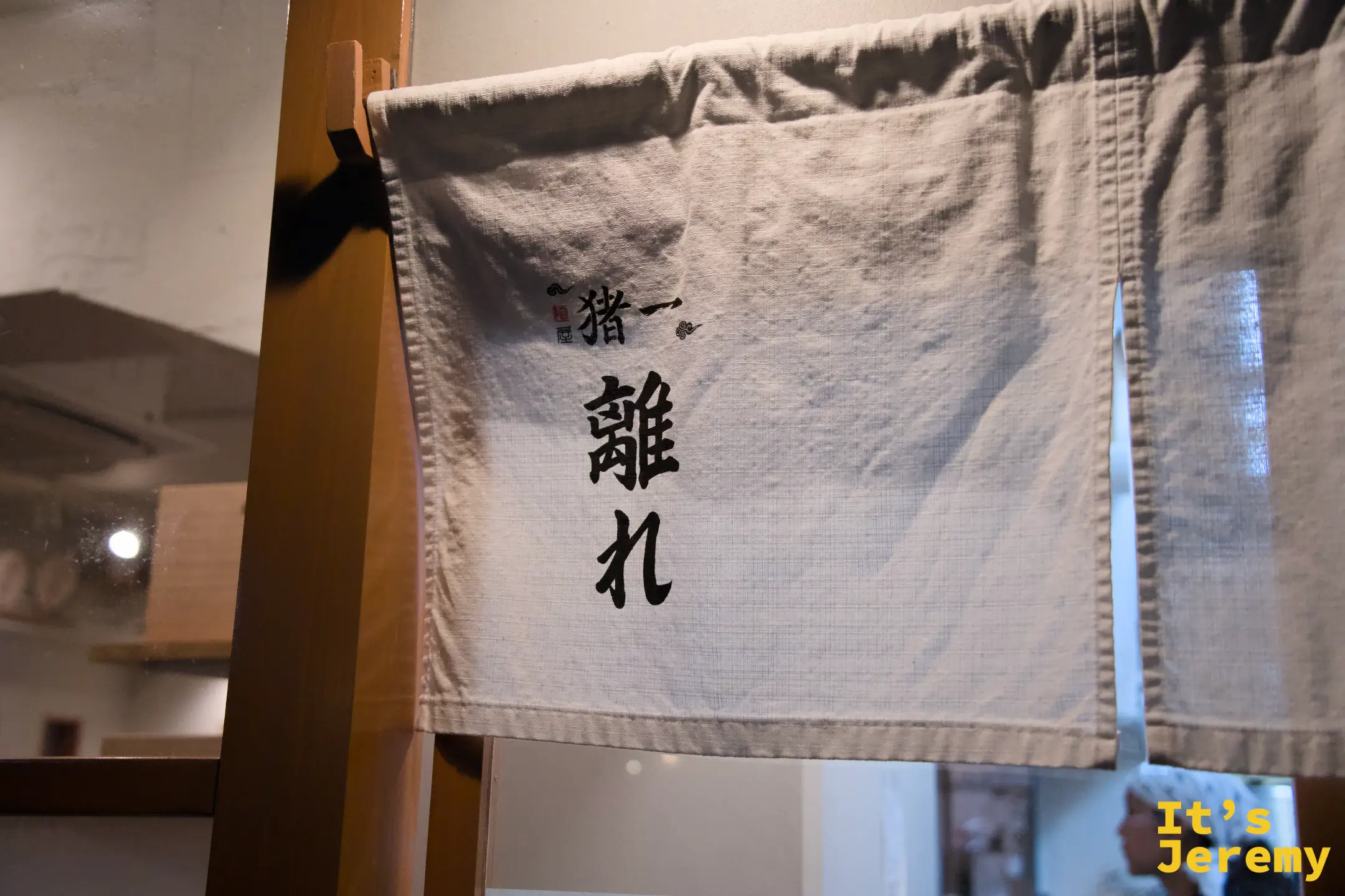 麺屋猪一入口的暖簾，墨字寫著猪一離れ