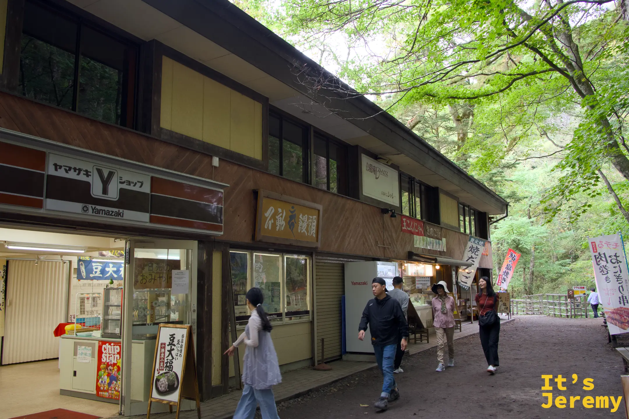 湯滝レストハウス與ヤマザキYショップ外觀，登山客在門口走動