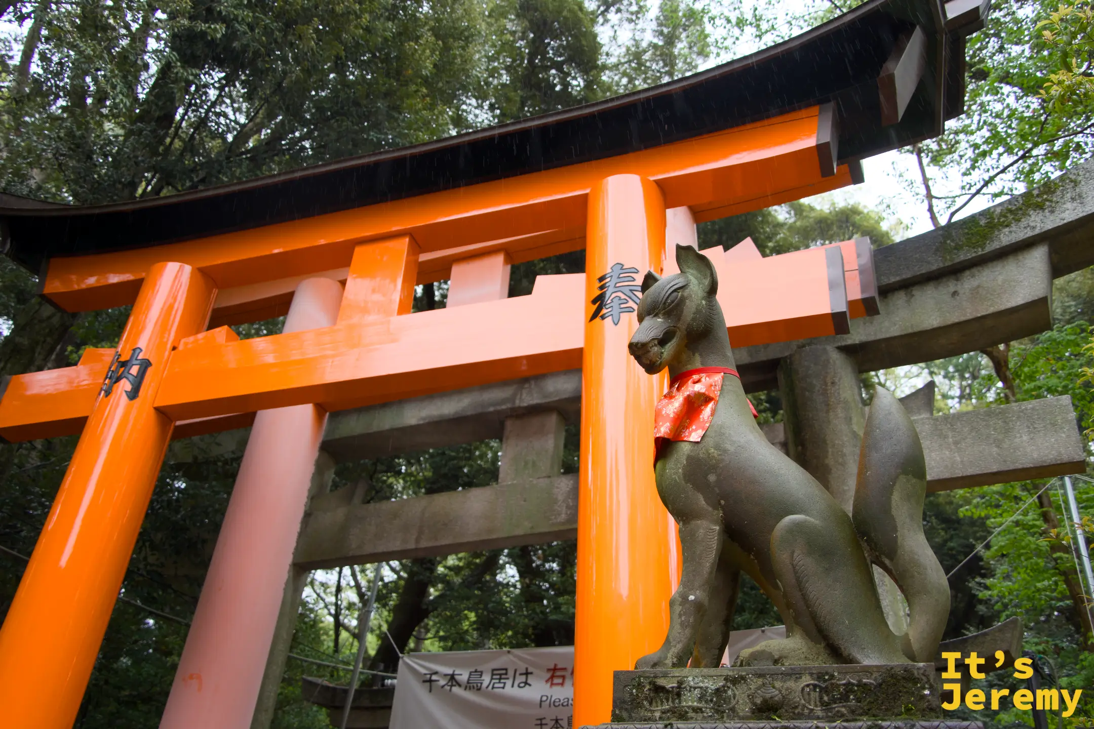 千本鳥居入口，石狐像守在側邊，告示牌寫著鳥居的意義