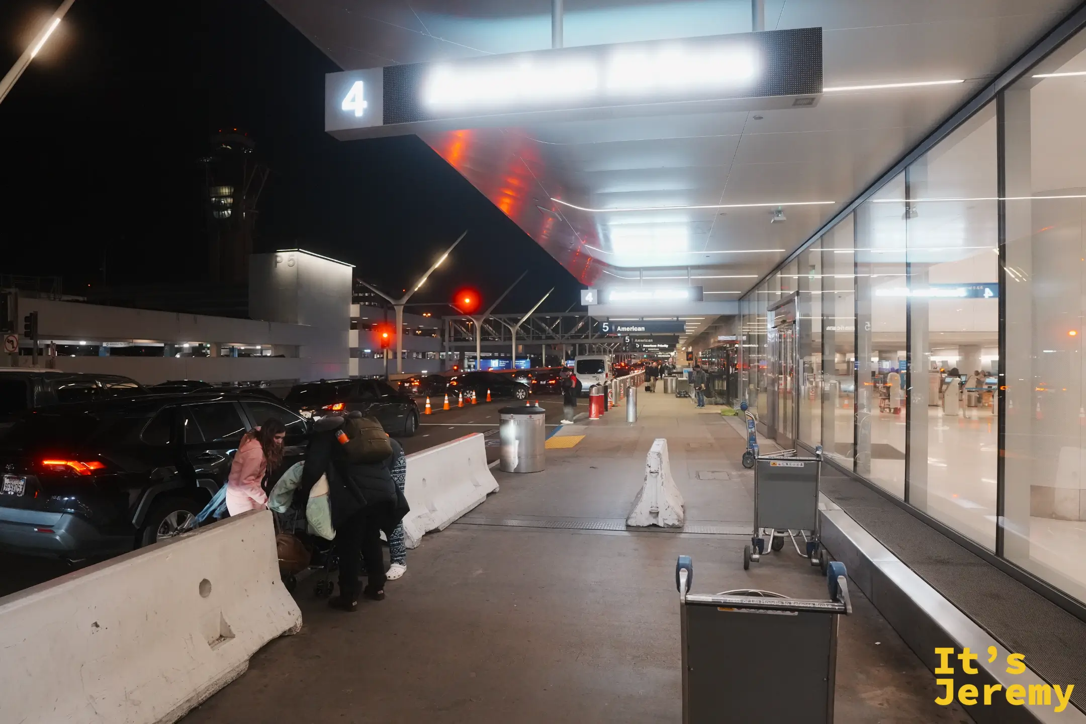 入夜的 LAX 航廈外，4 號門旁停著一排車，遠處是機場塔台的燈光