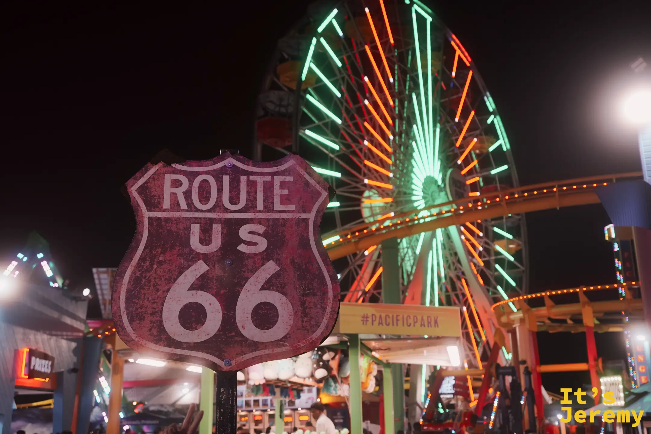 Route 66 End of the Trail 紅色盾形招牌與後方發光的摩天輪