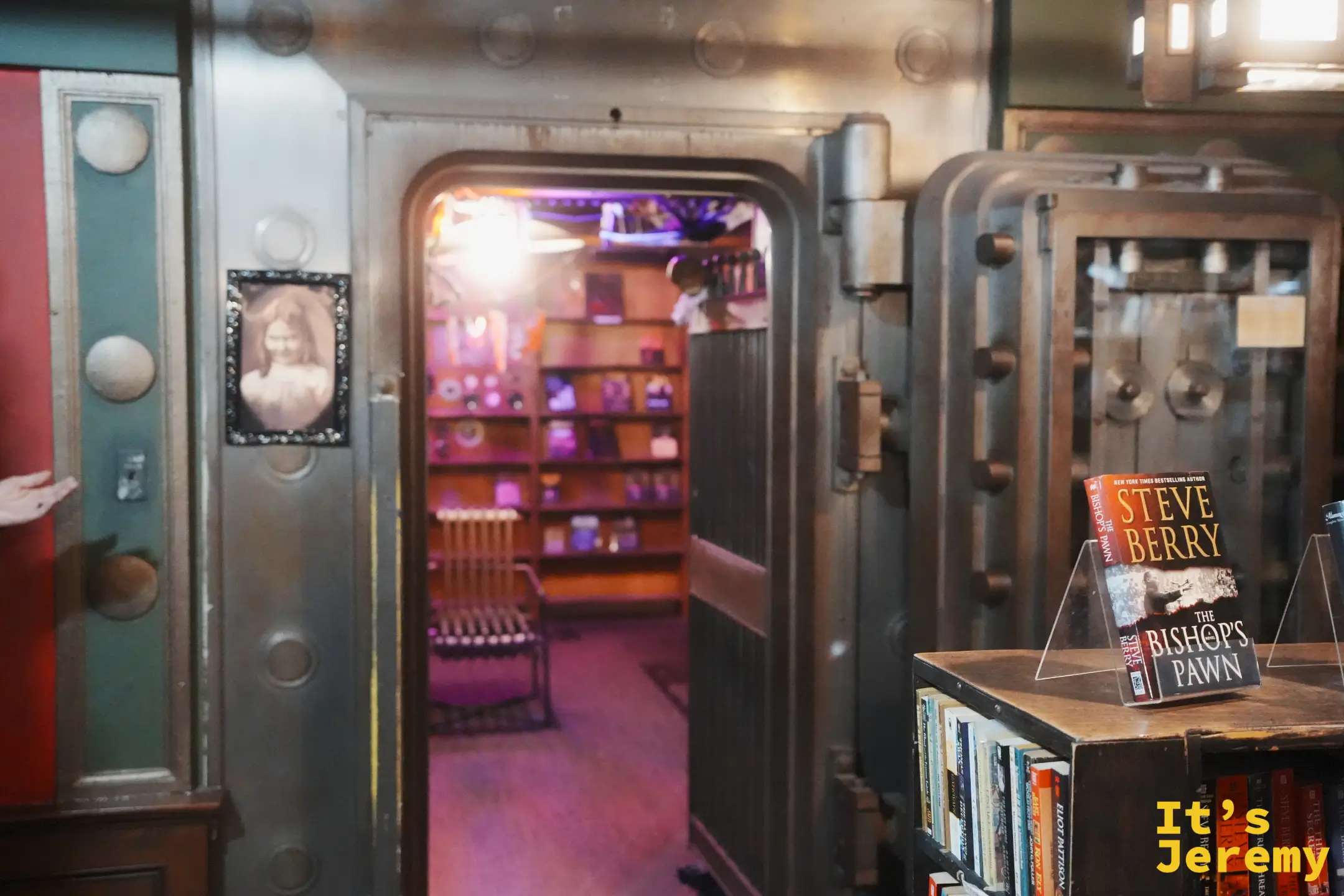 The Last Bookstore 保留的老銀行金庫金屬大門，門後是紫光的閱讀室與書架