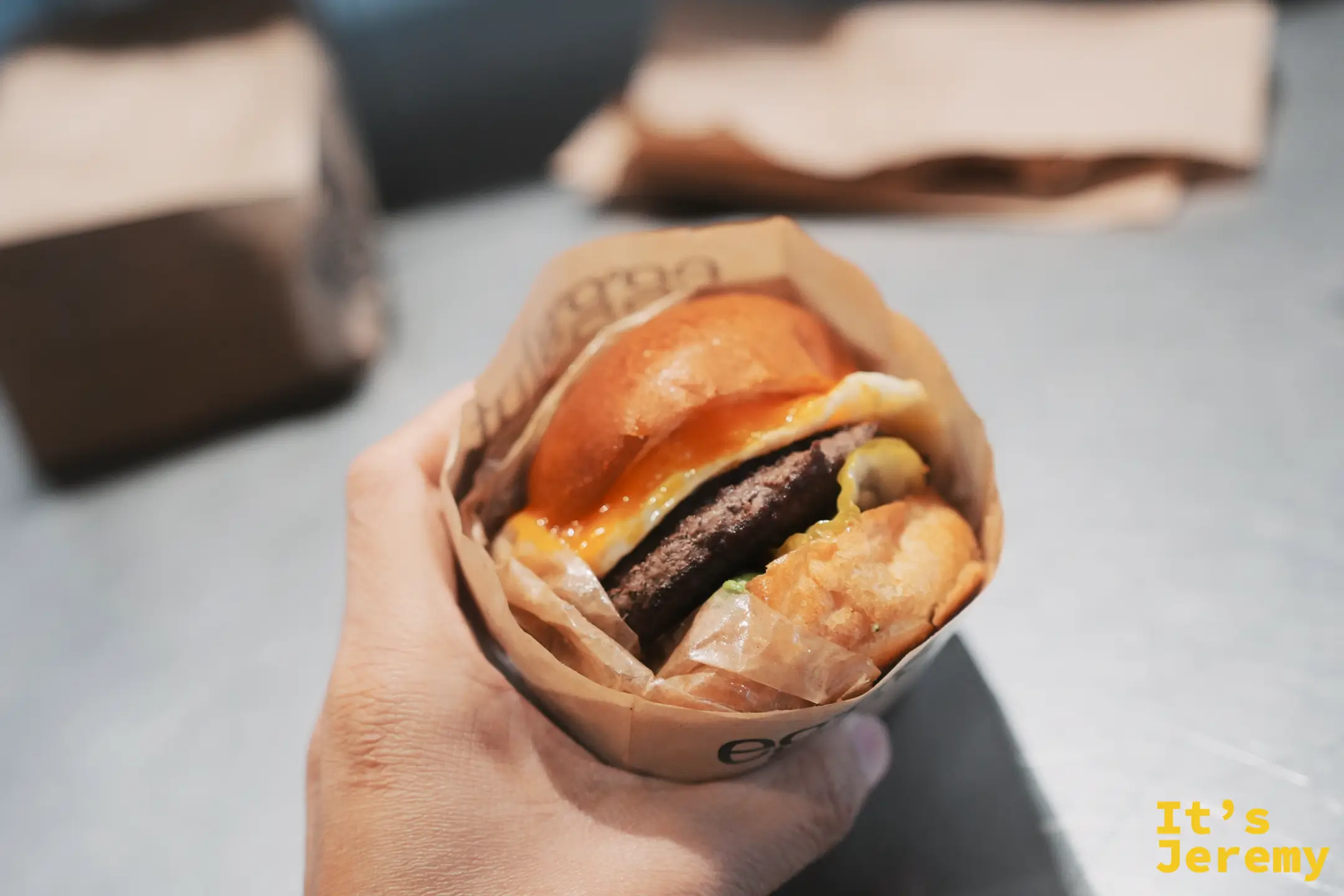 Eggslut 溏心蛋堡近拍，流心蛋黃與融化起司從麵包邊緣溢出