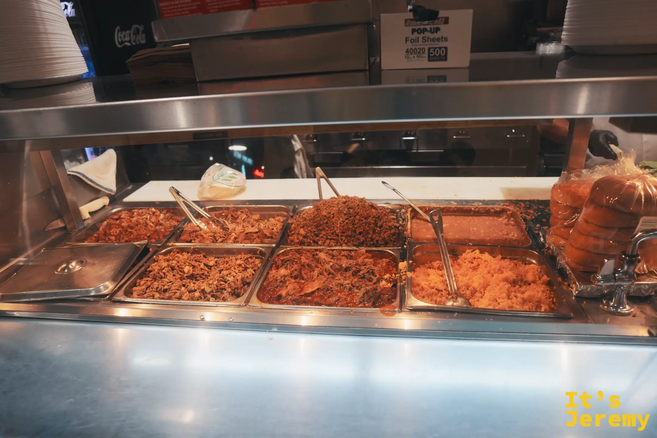 墨西哥攤位保溫檯裡各式燉肉餡料、米飯與玉米餅