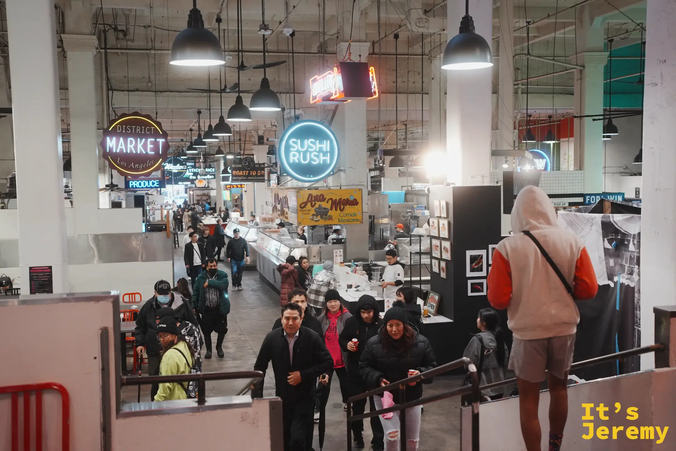 從樓梯往下看 Grand Central Market 走道，人群與 Sushi Rush 等攤位招牌
