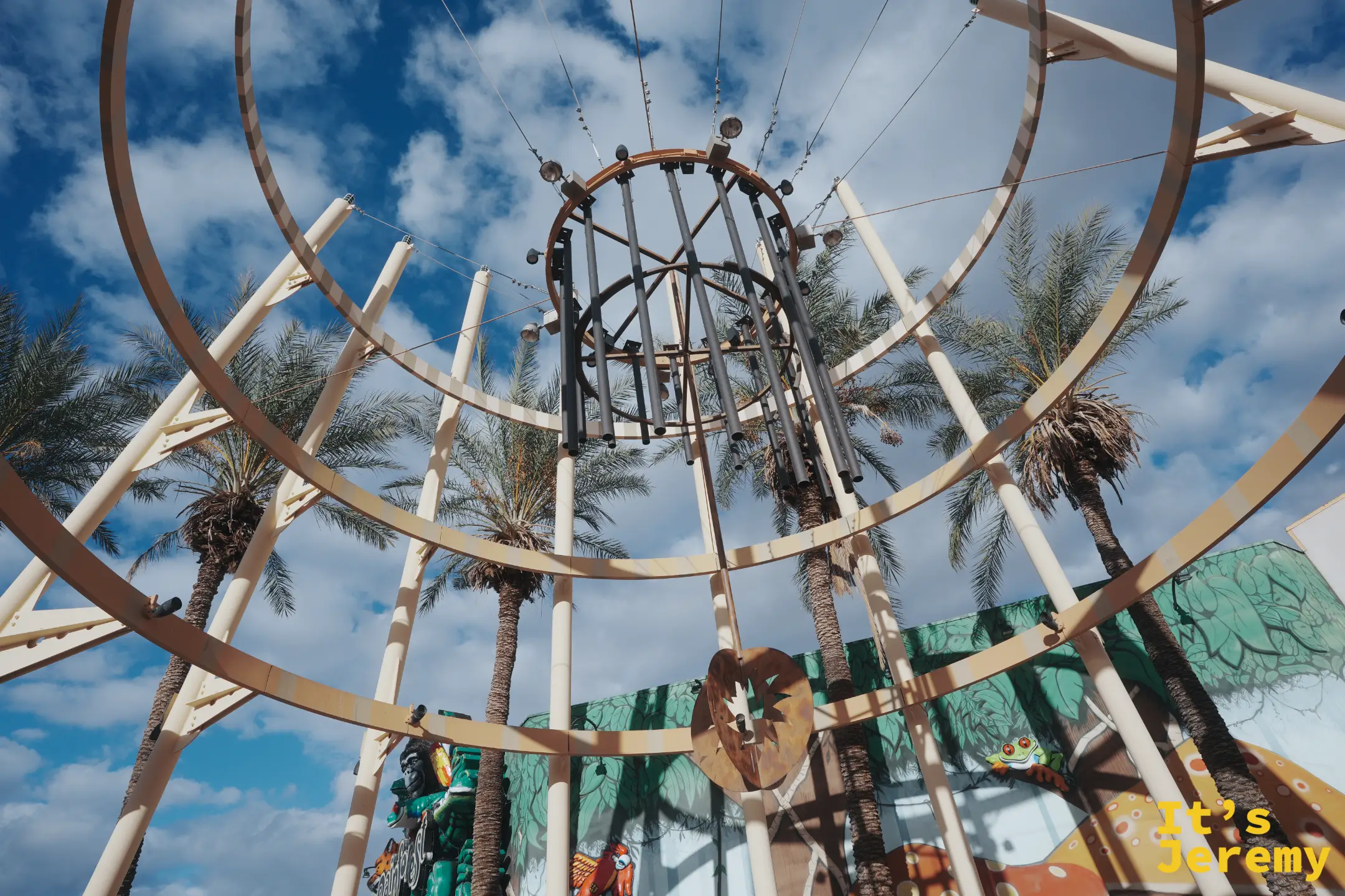 Arizona Mills 戶外入口的圓環金屬藝術裝置、棕櫚樹與 Rainforest Cafe 外牆彩繪