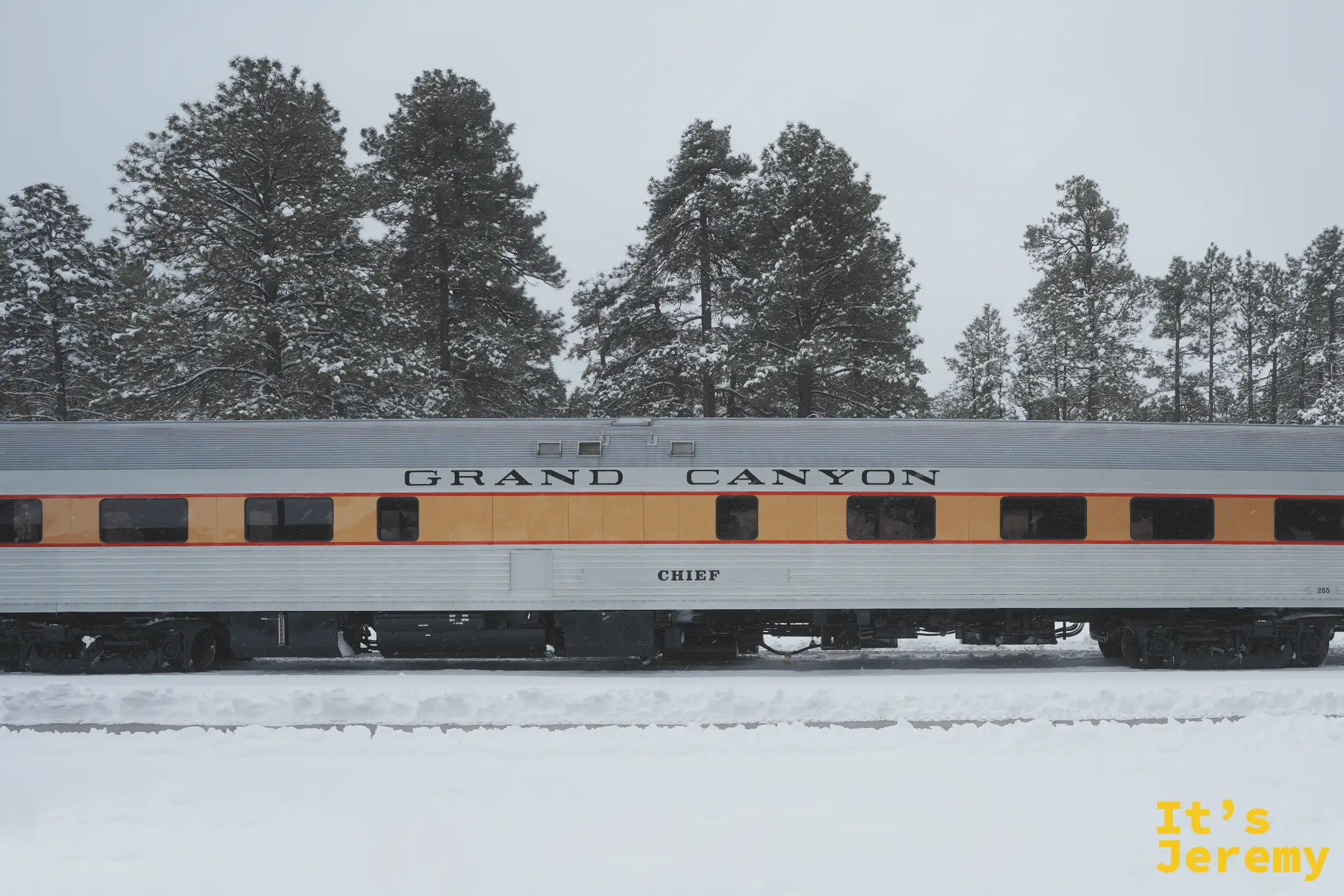 停在雪地裡的大峽谷鐵路車廂，車身寫著 GRAND CANYON