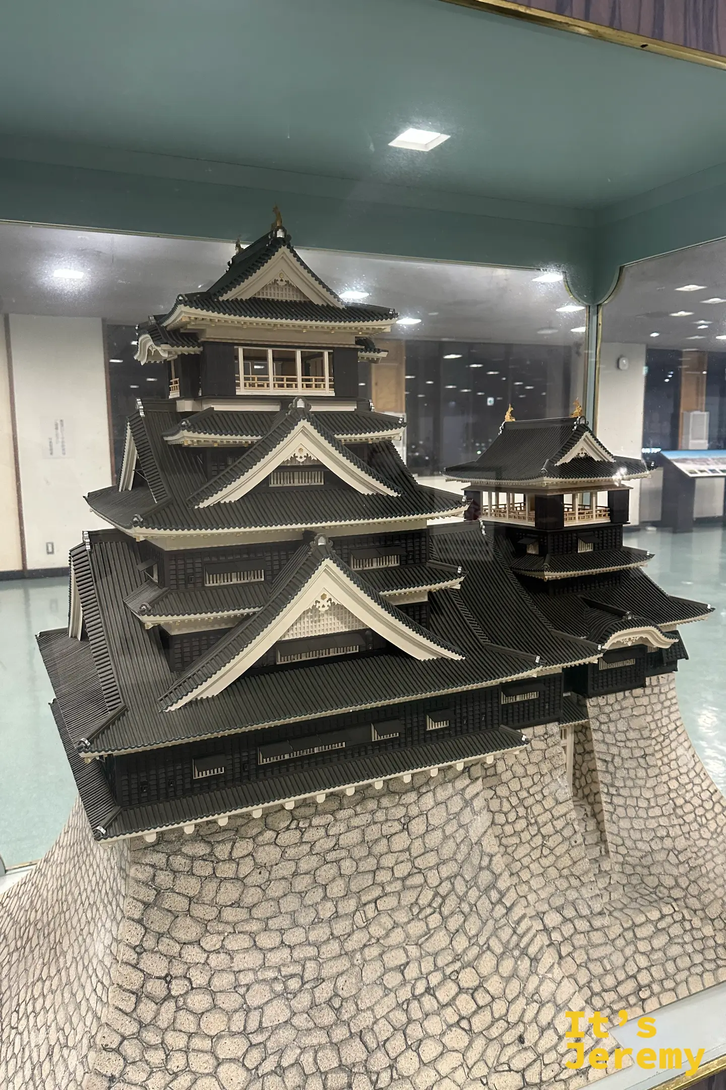 大廳玻璃櫃裡的熊本城復原模型，把大小天守的黑瓦白牆與層層飛檐做得極為細緻