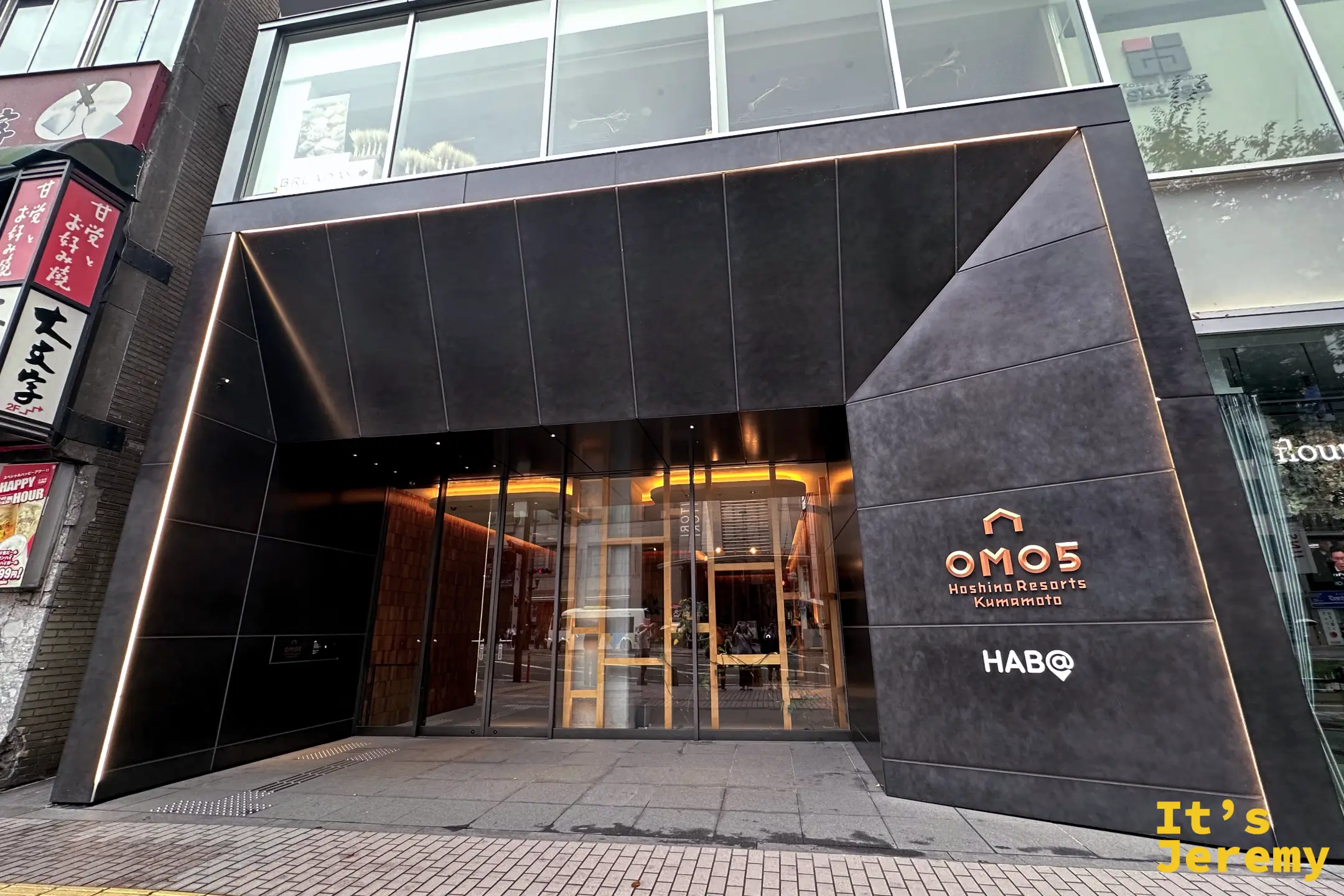 OMO5 by 星野リゾート 熊本的飯店入口，黑色現代感的門面，牆上有 OMO5 Hoshino Resorts Kumamoto 與 HAB@ 標誌