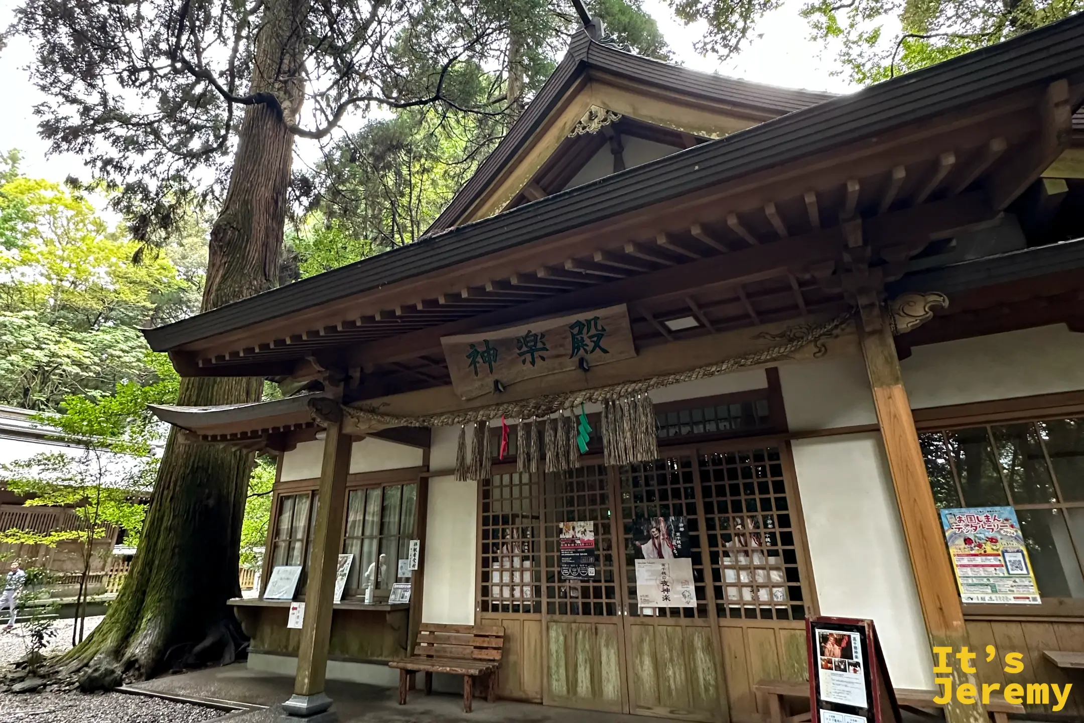 高千穂神社的神楽殿，門口掛著「神楽殿」匾額與夜神樂海報