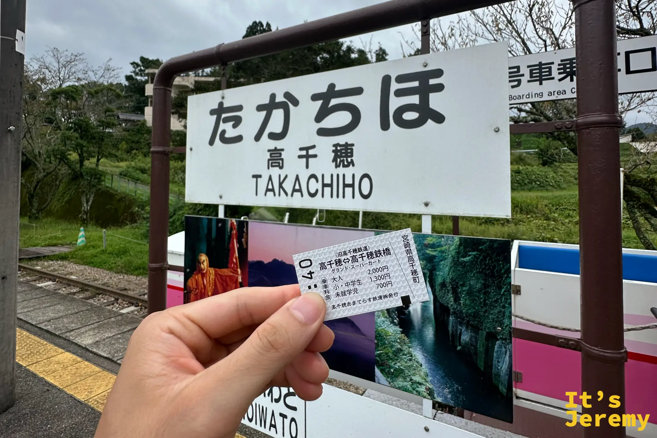 手持あまてらす鉄道乘車券，背景是たかちほ車站站牌