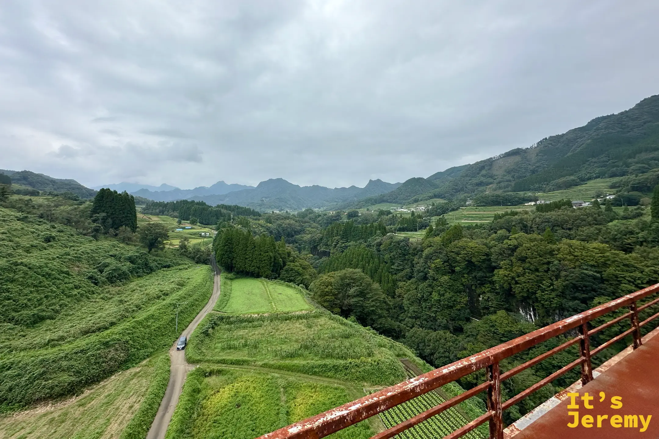 從高千穂鐵橋上俯瞰山谷，一百公尺下的谷底道路蜿蜒成細線，遠處群山連綿