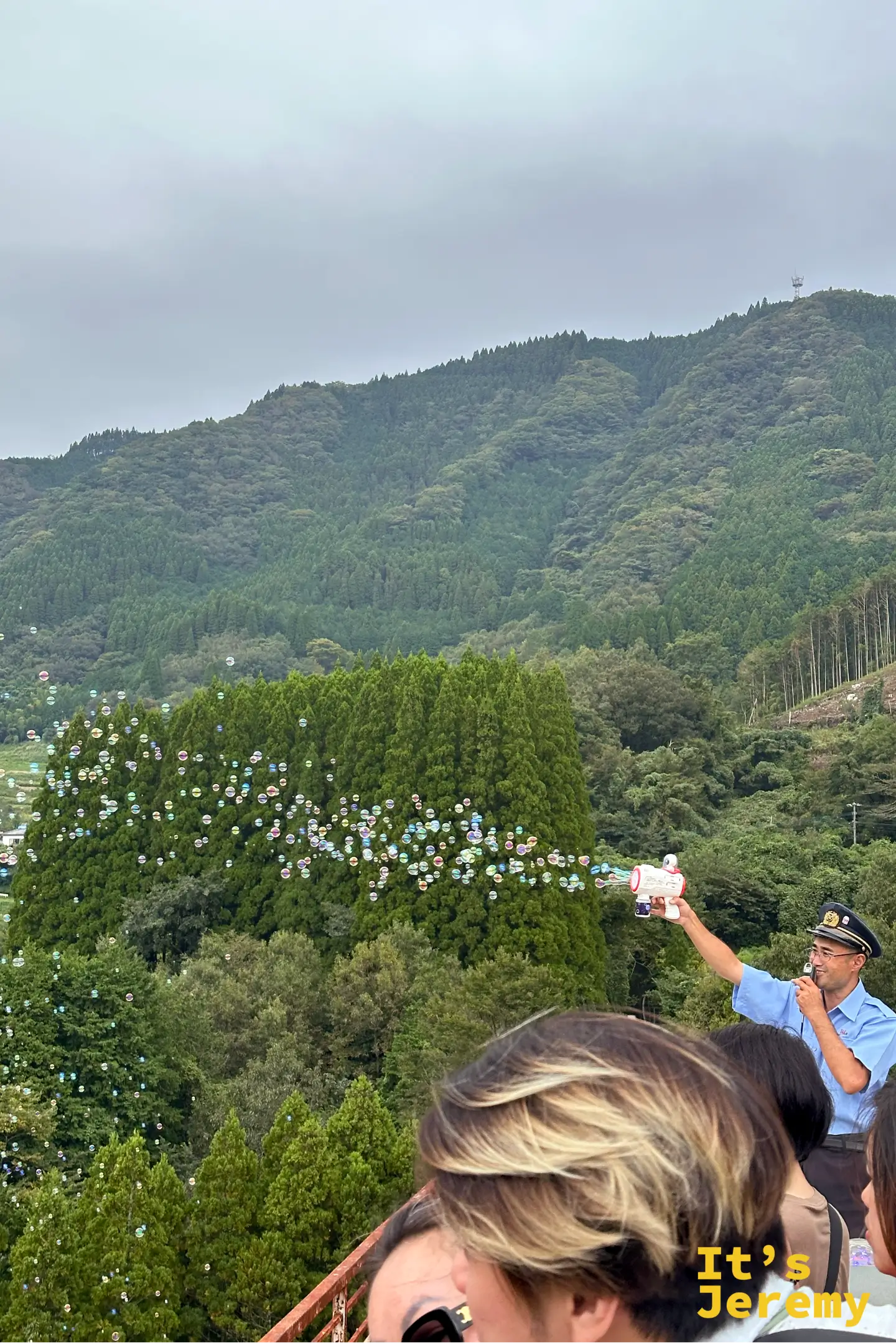 車掌在鐵橋上拿泡泡槍朝山谷噴出滿天泡泡