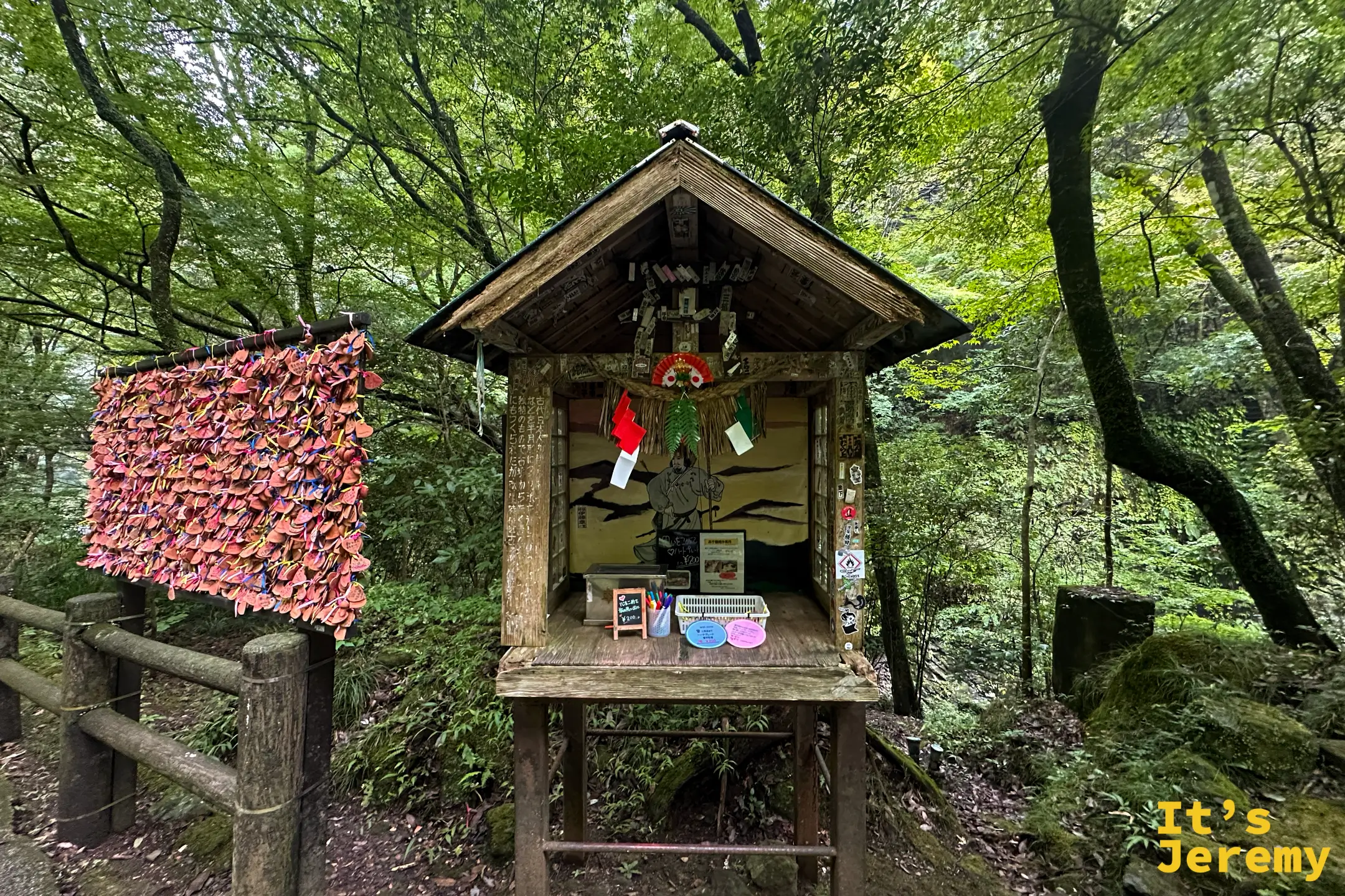 願望小屋前掛滿愛心陶片，屋內有神話人物木牌