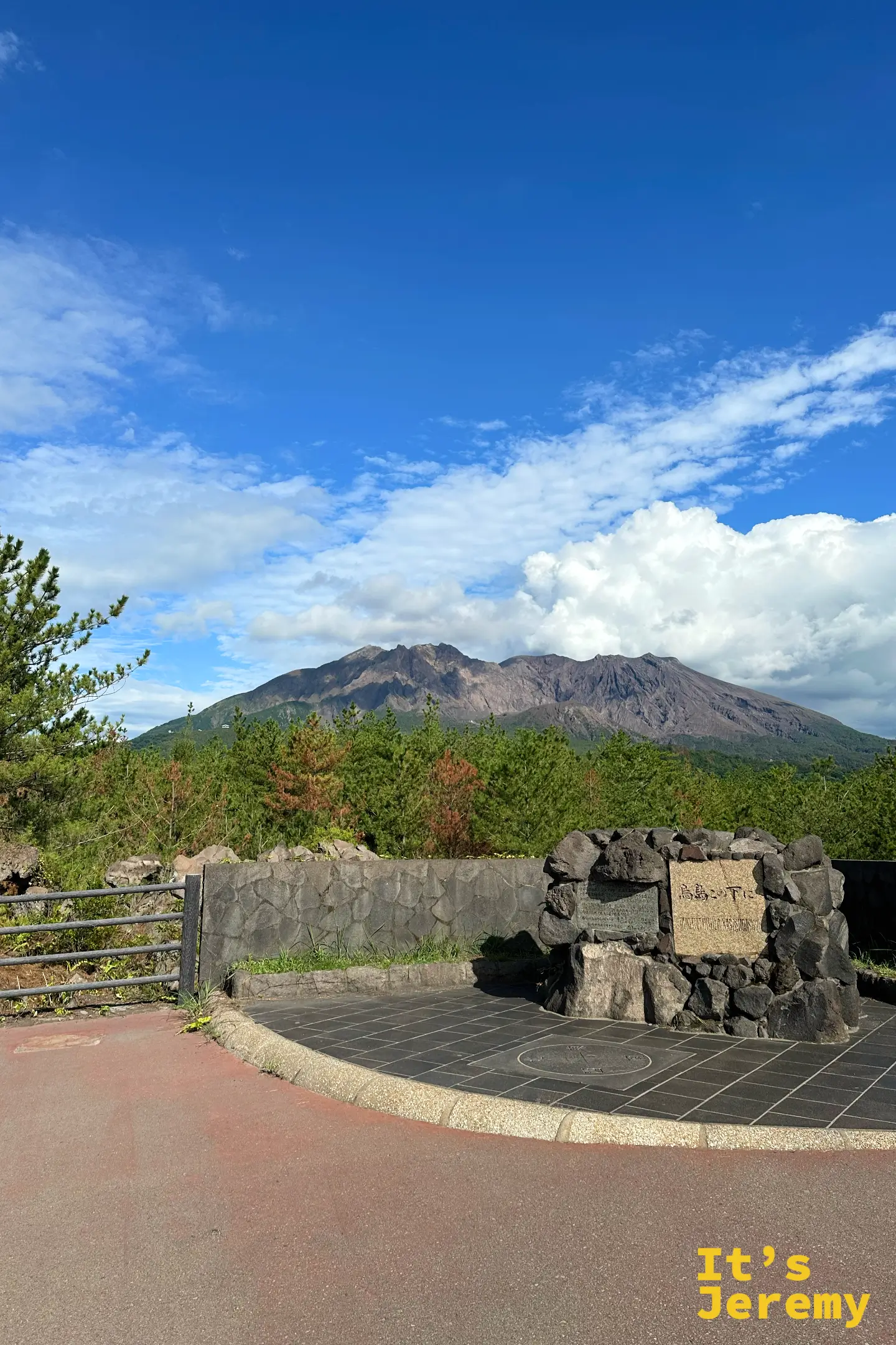 烏島展望所的「烏島この下に」熔岩石紀念碑，後方是綠意山腹的櫻島