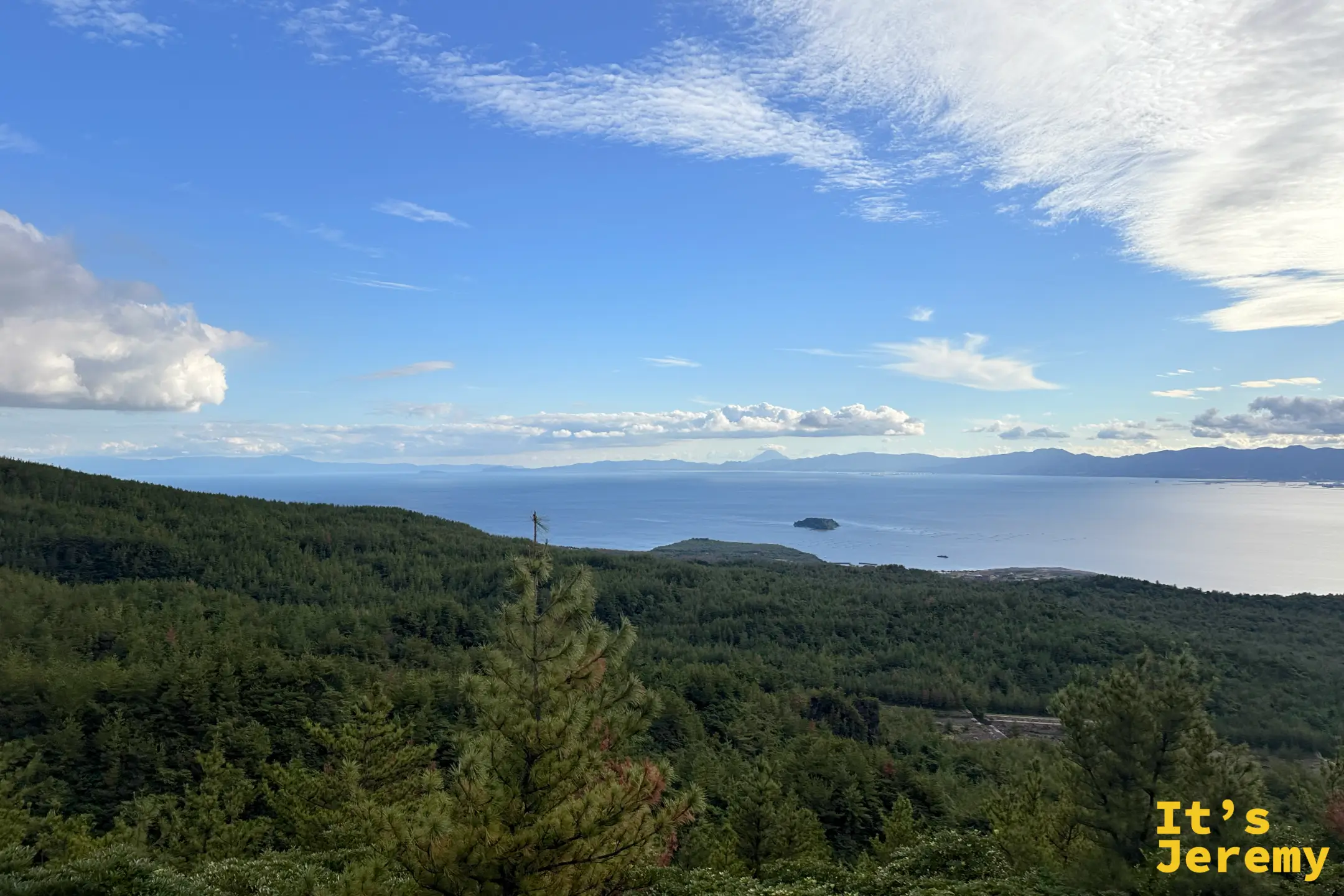 「湯之平展望所 標高373m」的黑色石碑，後方是布滿溝壑的櫻島山體與山頂噴煙
