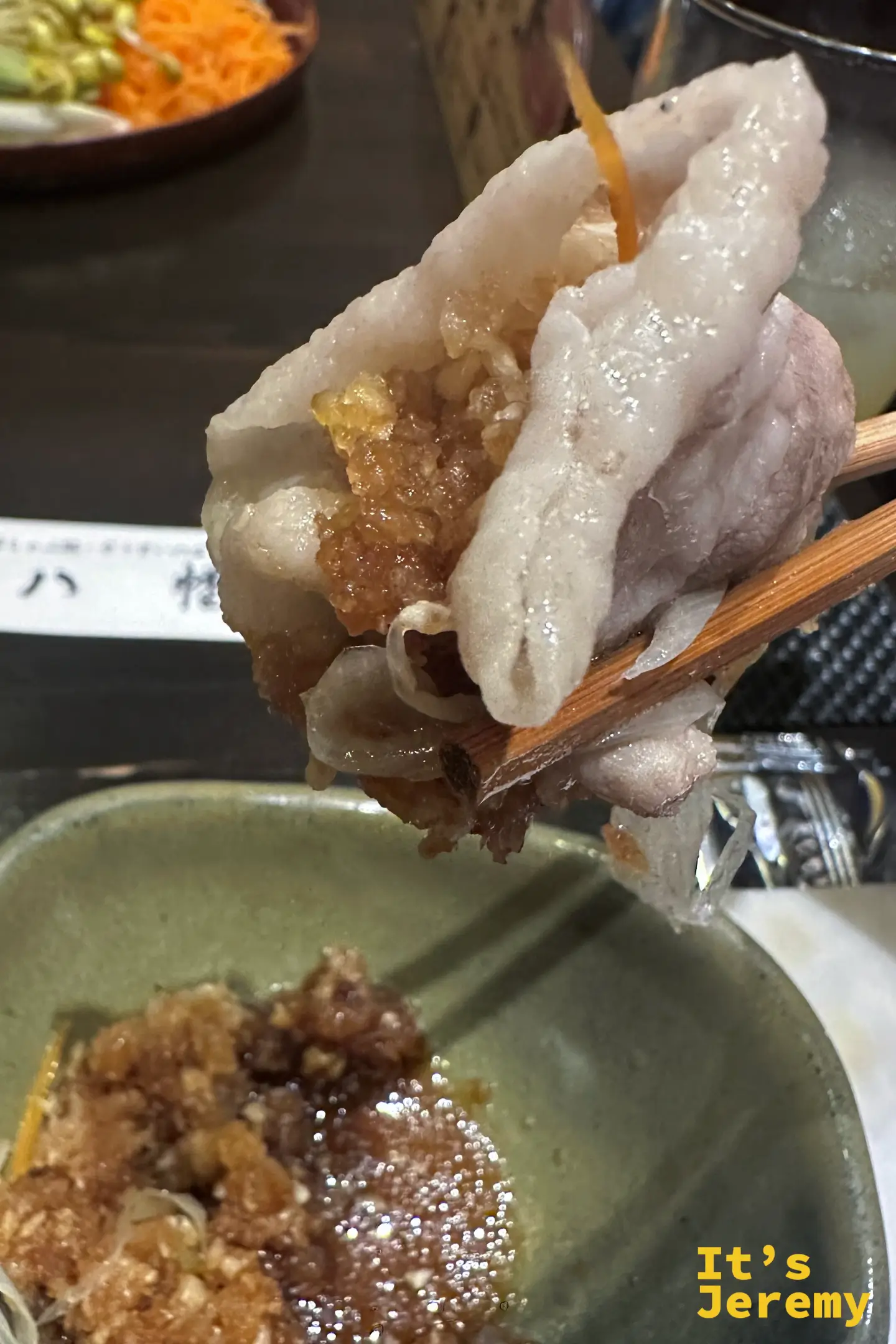 筷子夾起一片涮好的黑豚，裹著蘿蔔泥蘸醬，肉片邊緣捲曲透亮